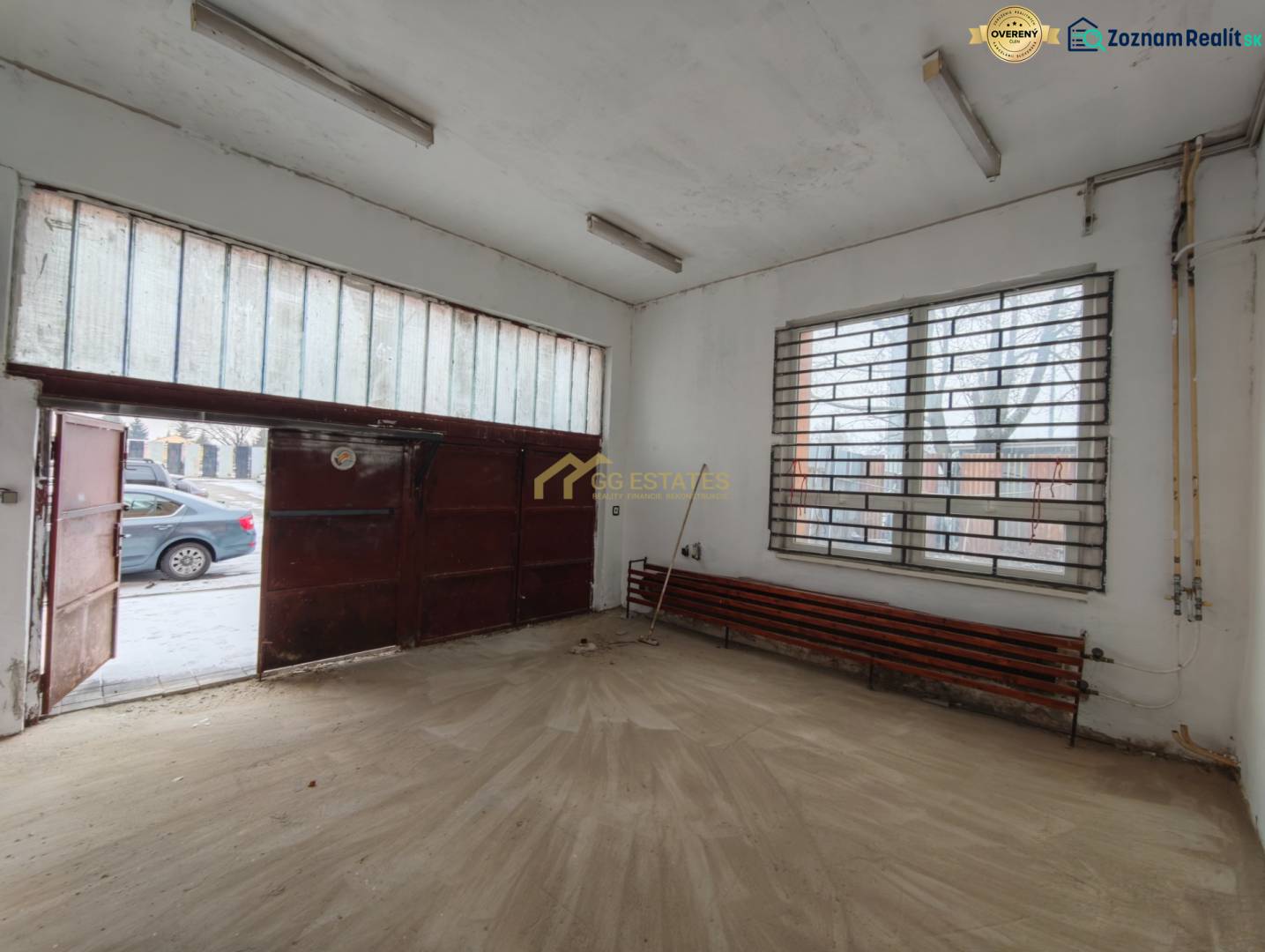 Garázs belső tér fa dekorációval ellátott padlóval és fém kapuval.