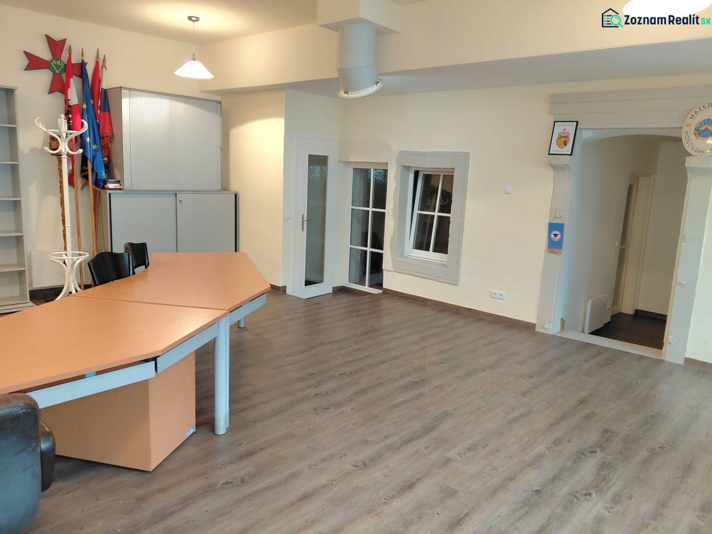 Irodák fa dekor padlóval, asztallal és szekrényekkel.