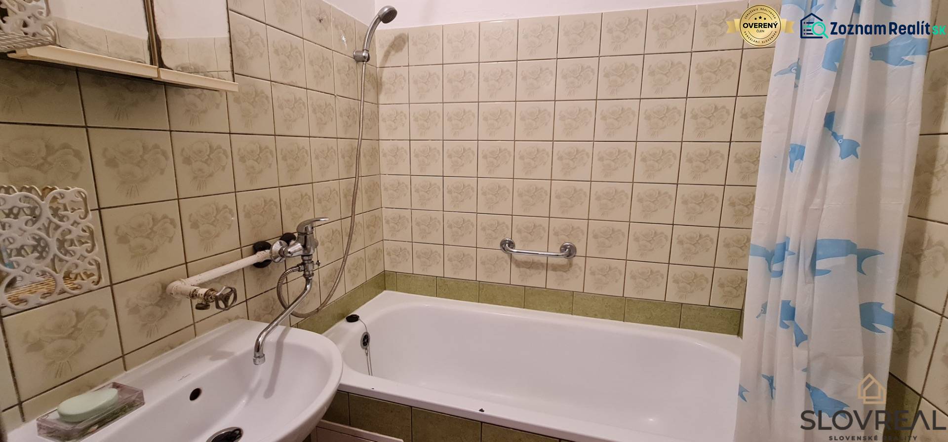 Fürdőszoba tükörrel és káddal egy háromszobás lakásban, dekoratív csempével burkolva.