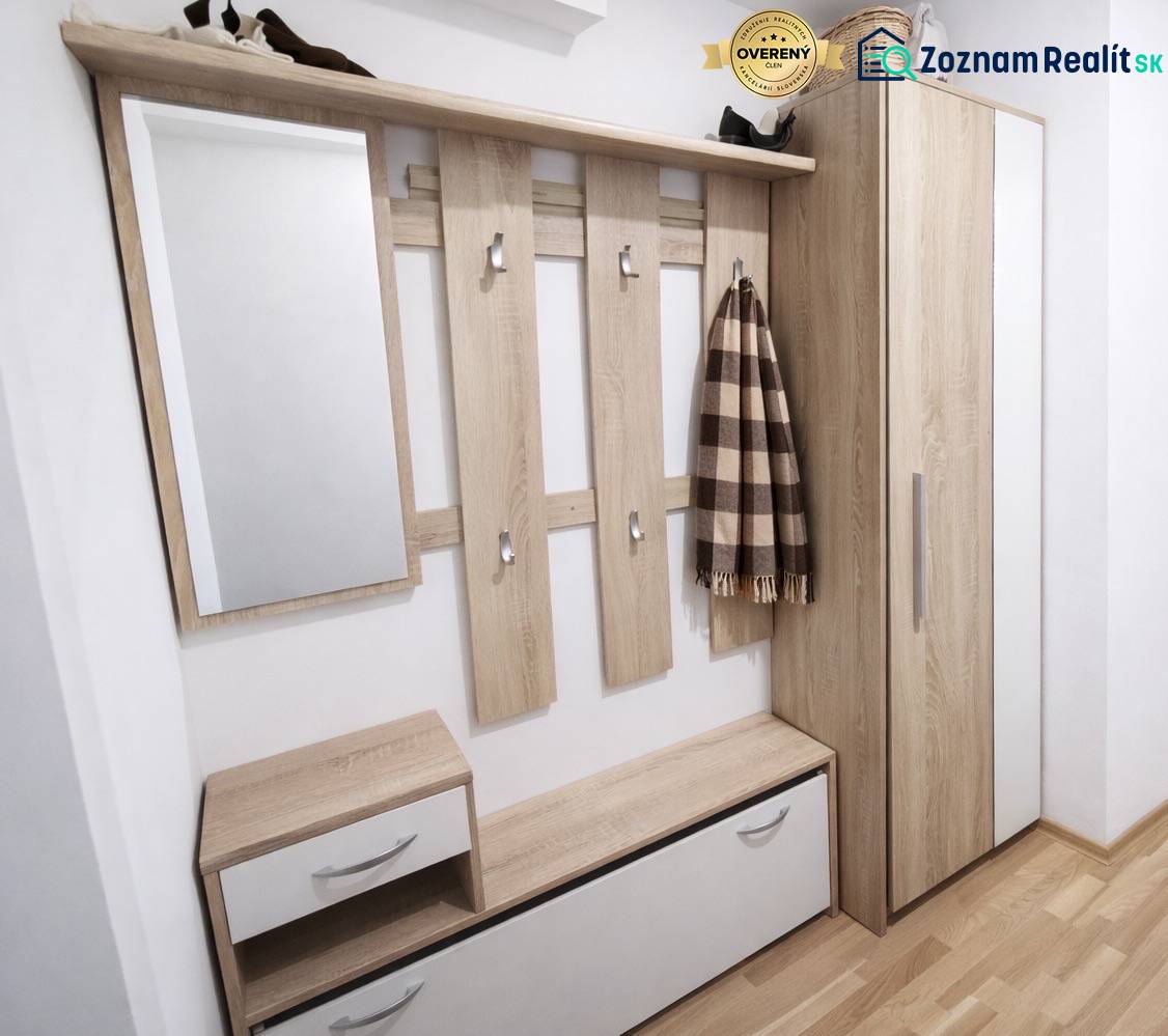 Bejárati folyosó egy kétszobás lakásban fa dekorációjú padlóval és tárolóhellyel.