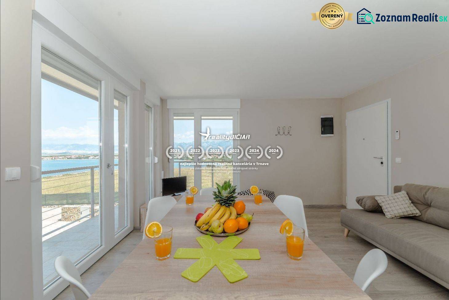 Étkezőasztal a tengerre néző nyaraló apartmanban nagy ablakokon keresztül.