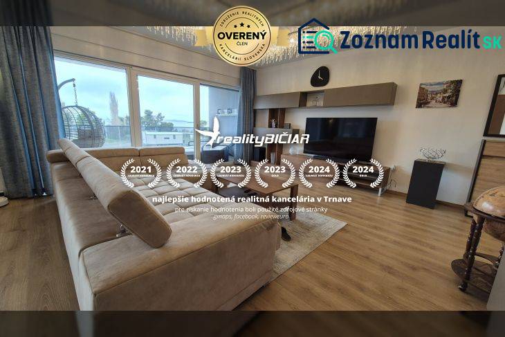 Nappali a nyaraló apartmanban kanapéval és fa dekorációjú padlóval.