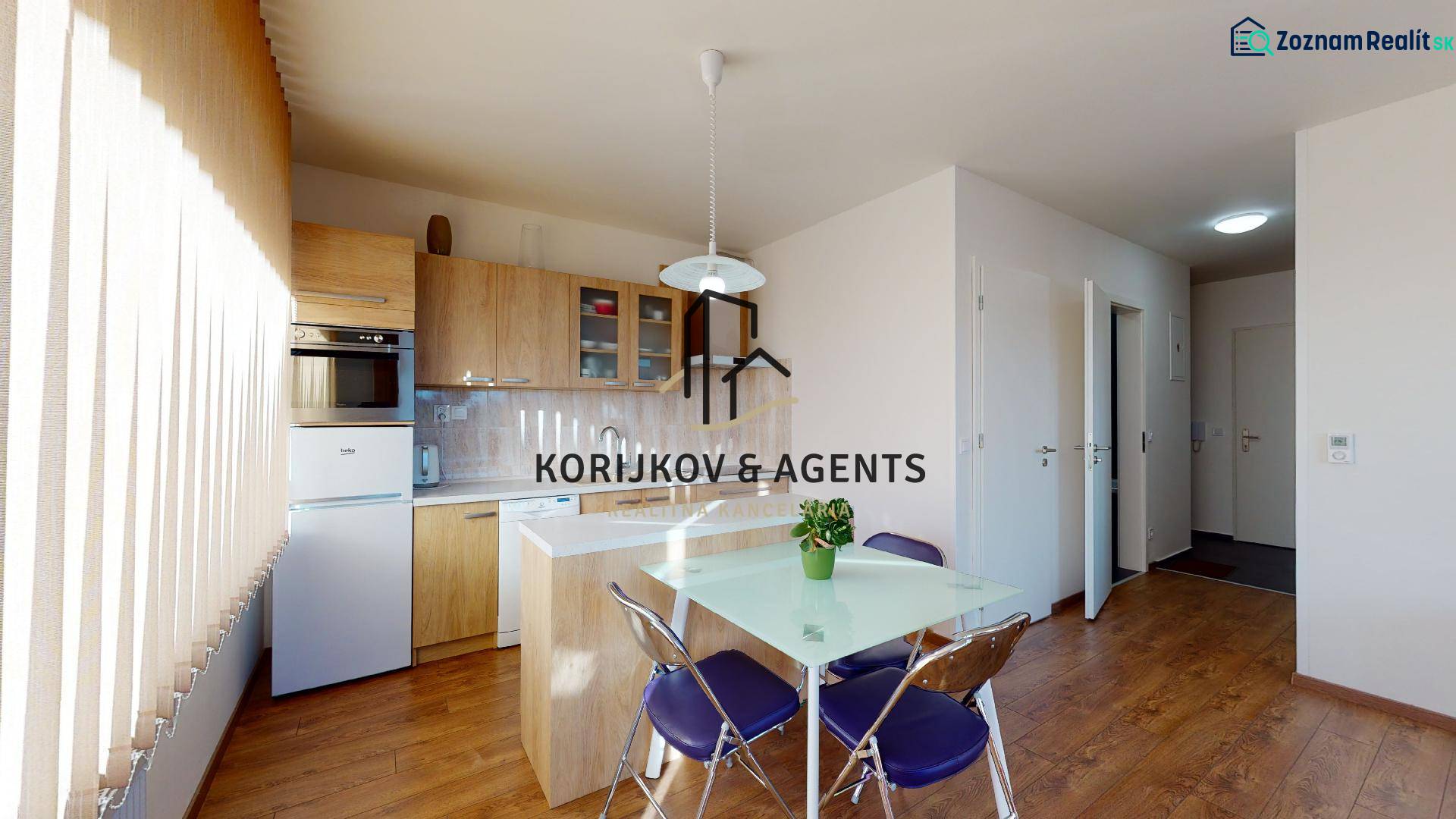 Konyha egy kétszobás lakásban, fa mintázatú padlóval és asztallal székekkel.