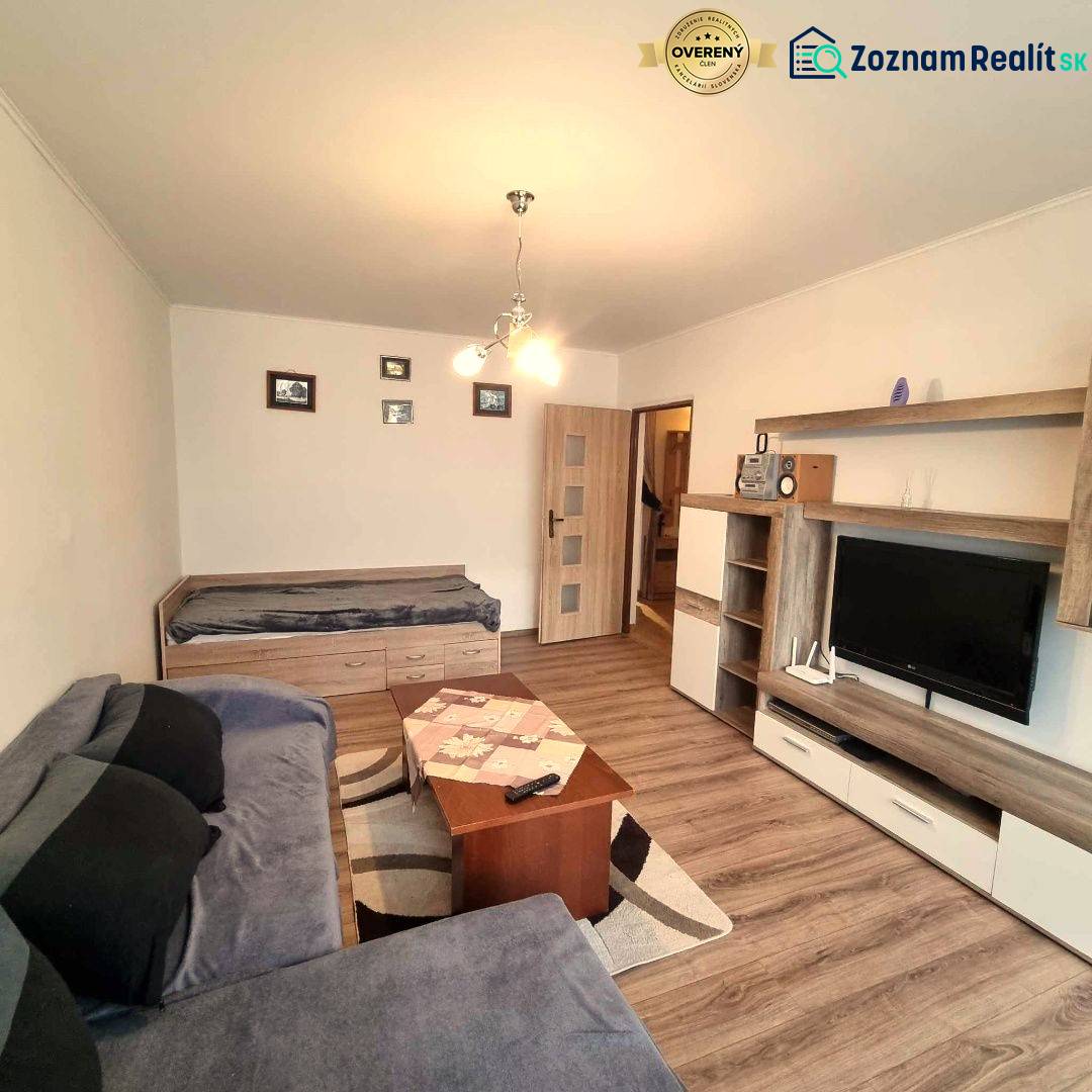 Nappali fa dekor padlóval egy kétszobás lakásban, kanapé és televízió.