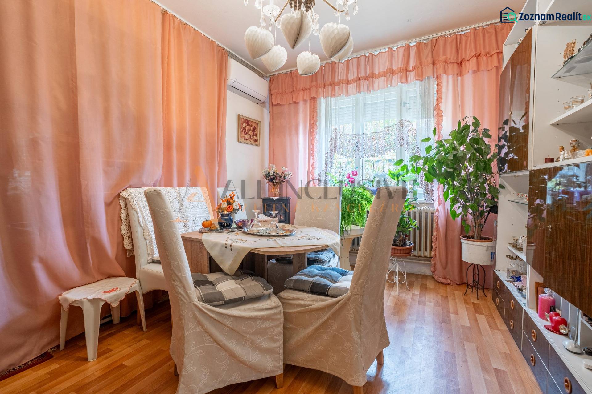 Ebédlő egy családi házban, csavarok a falon, szobanövények, fa dekorációjú padló.