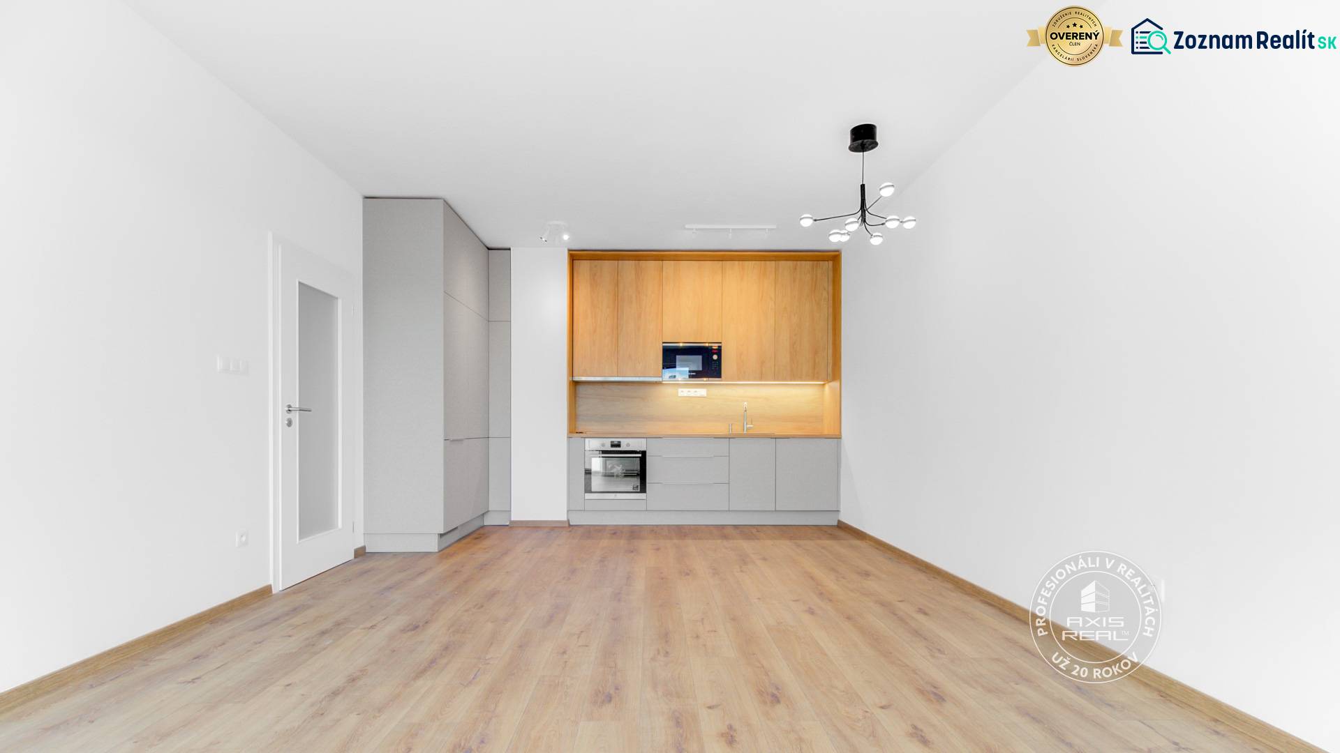 Világos konyha egy kétszobás lakásban, fa dekoros padlóval és fehér falakkal.