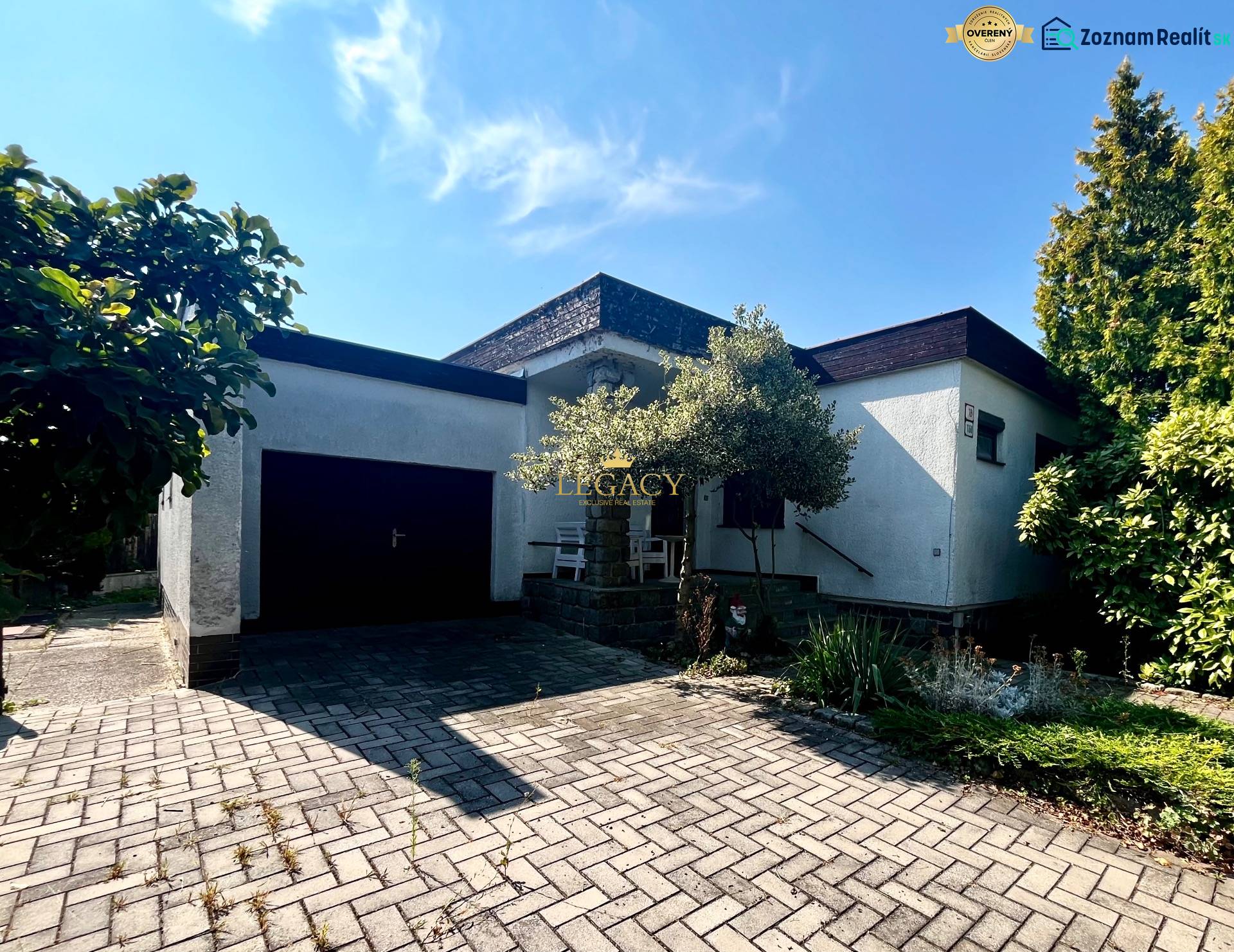 Családi ház Ivanka pri Dunaji-ban garázzsal és virágágyással, a kövezett járdán.