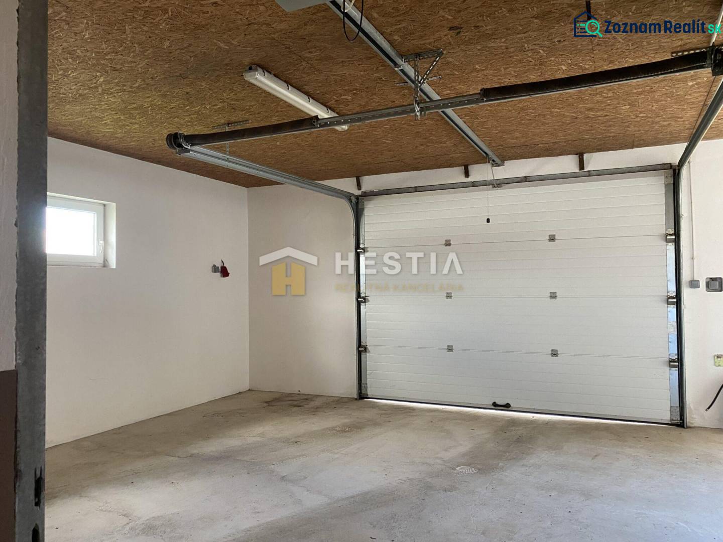 Raktárak és csarnokok belső tere garázskapukkal és betonpadlóval.