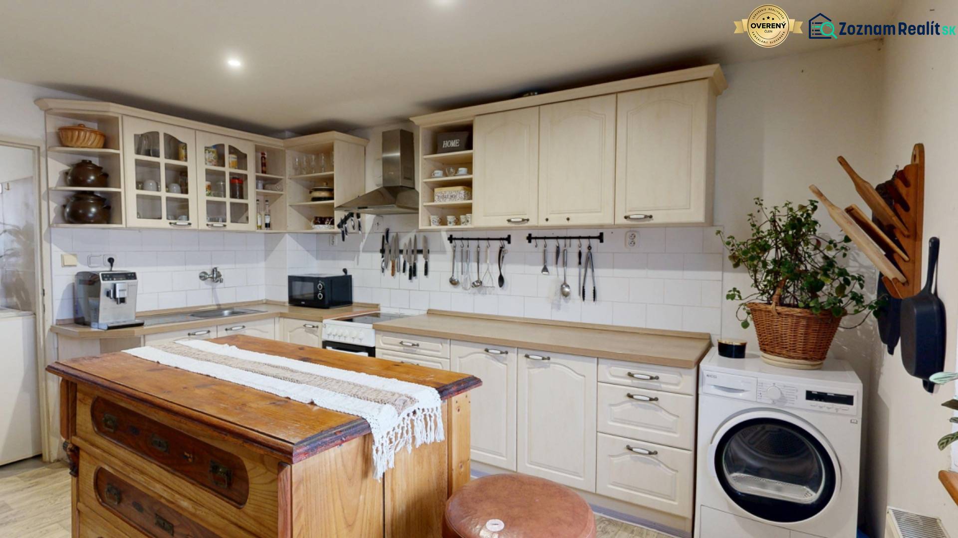 Konyha vintage szigettel, konyhaszekrényekkel, mosogatóval és mosógéppel egy családi házban.