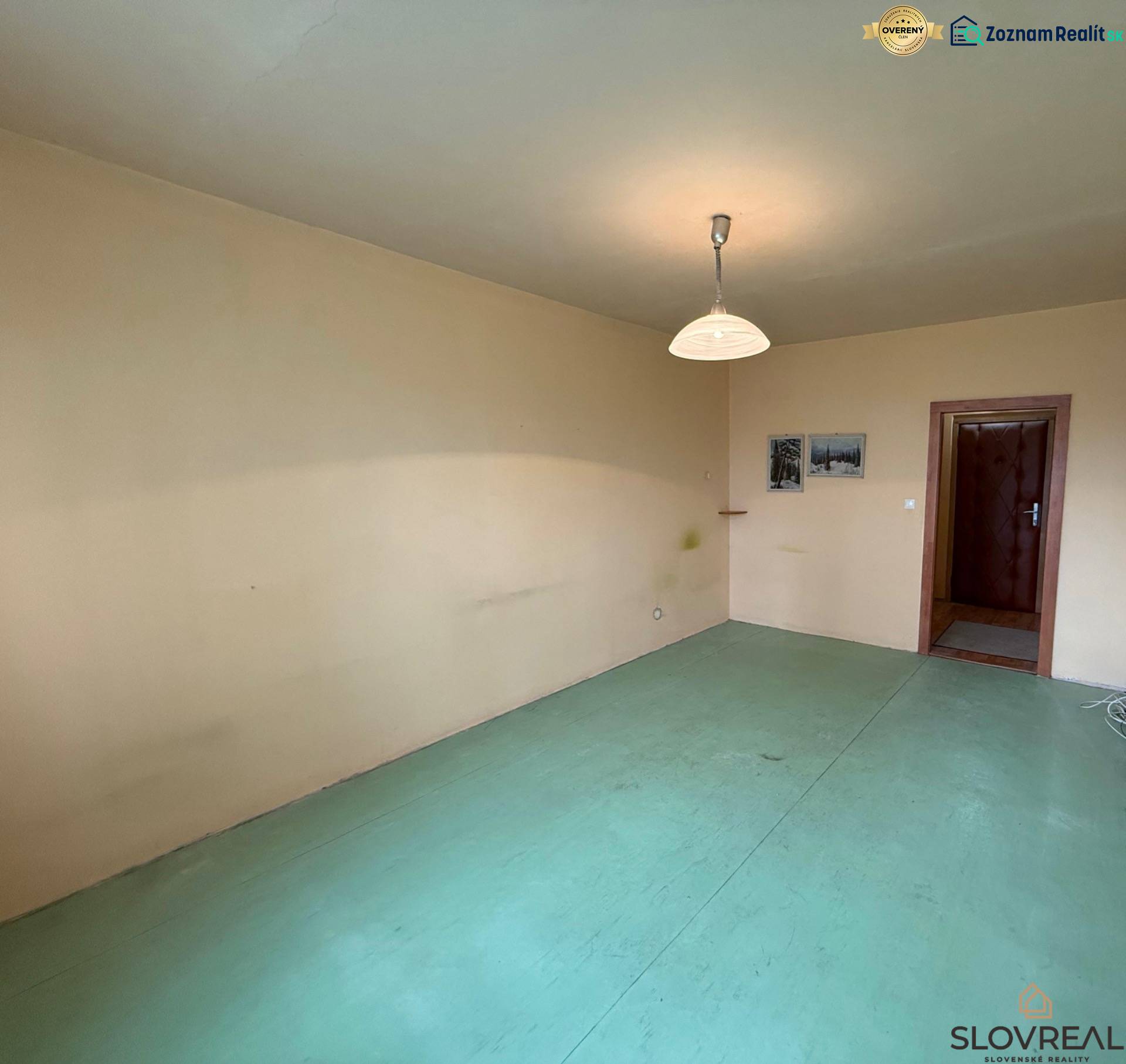 Szoba egy háromszobás lakásban semleges falakkal és világos padlóburkolattal.