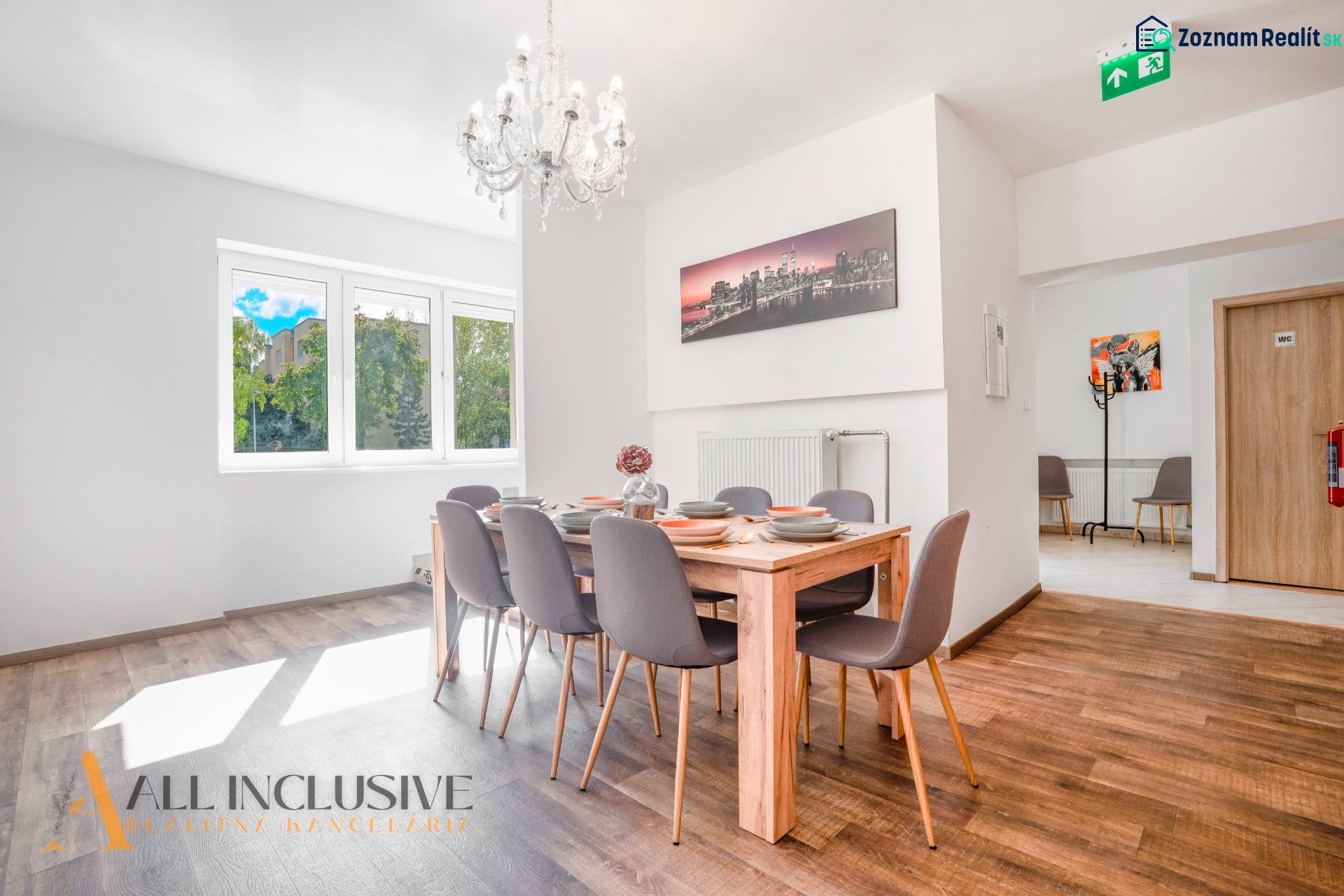 Ebédlő csillárral és fa dekorációjú padlóval az épületben.