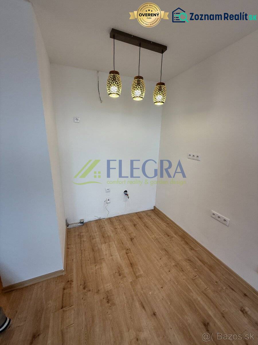 1 szobás lakás belső tere fa mintázatú padlóval és függő világítótestekkel.