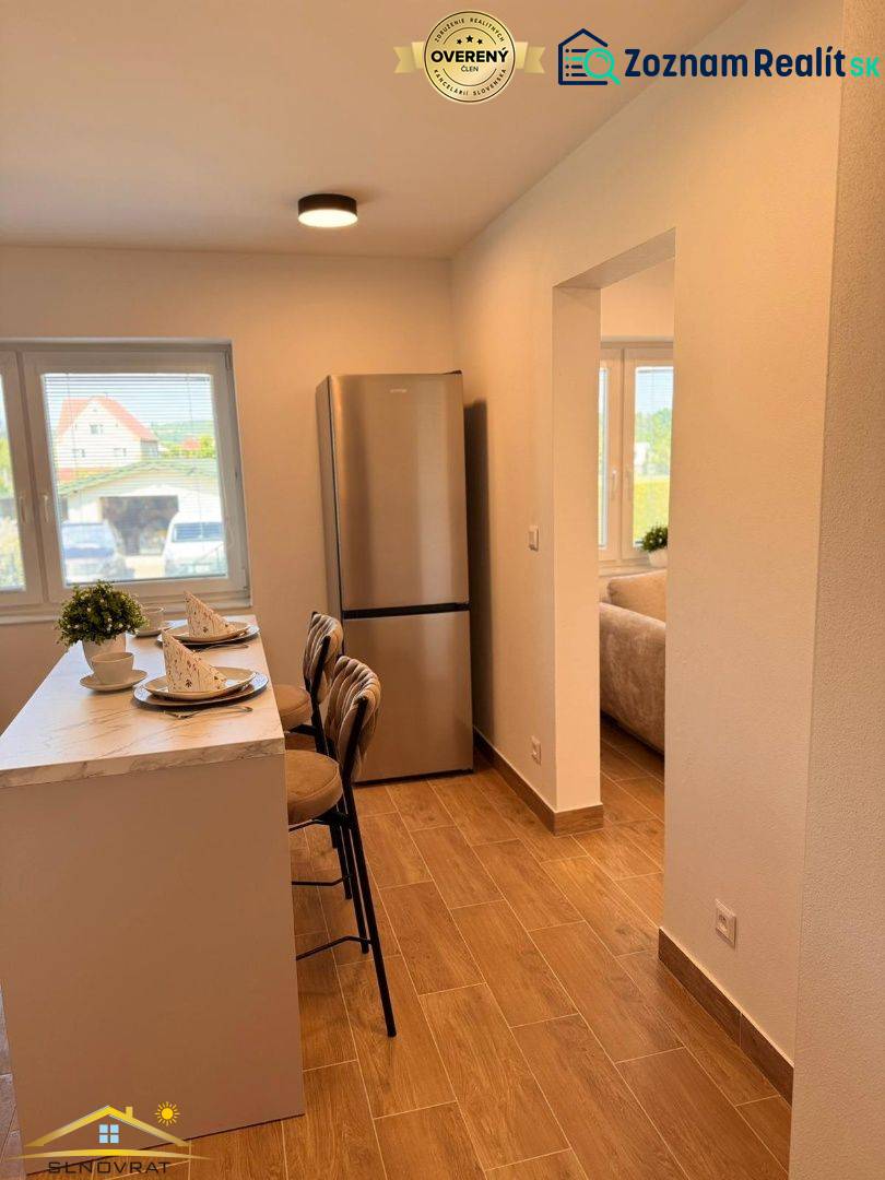 Konyha egy 2 szobás lakásban bárral, fa dekorációjú padlóval és hűtőszekrénnyel.