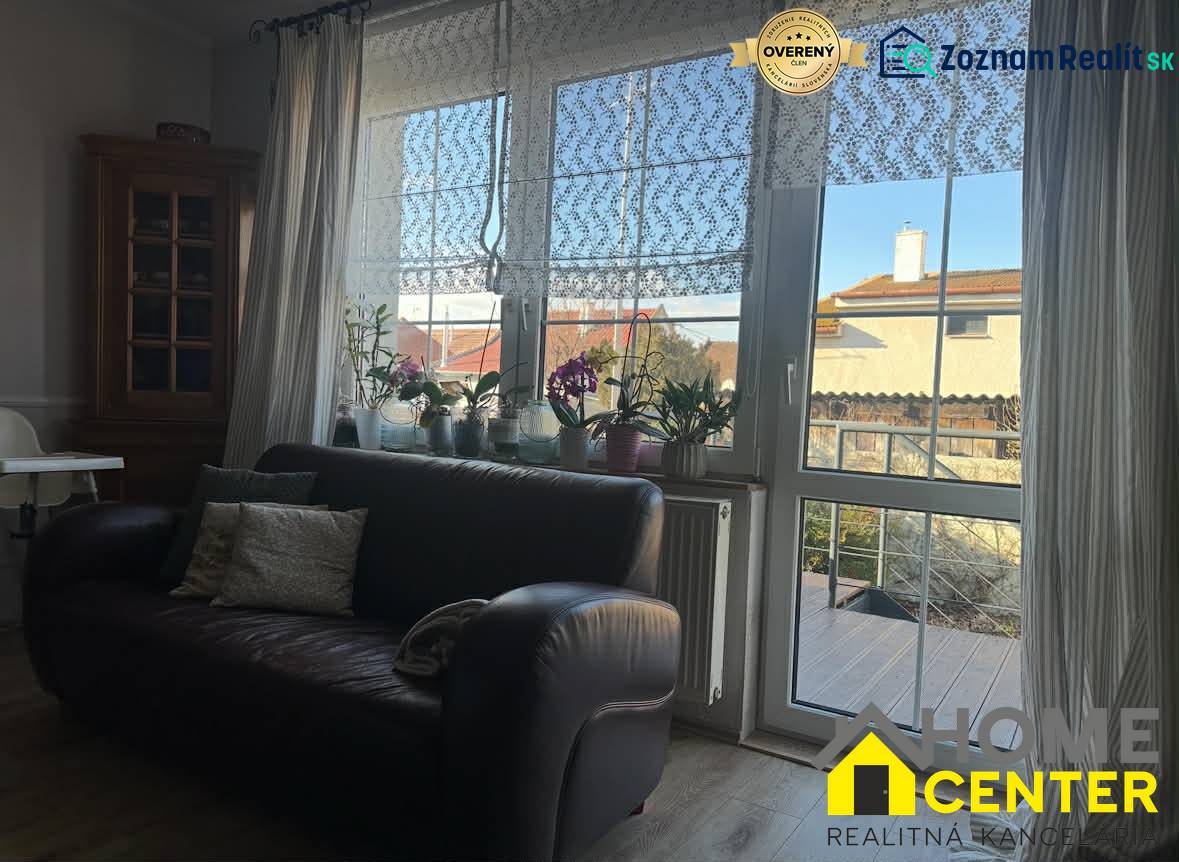 Bőr kanapé és ablak csipkefüggönyökkel a családi házban, fa dekoros padlóval.