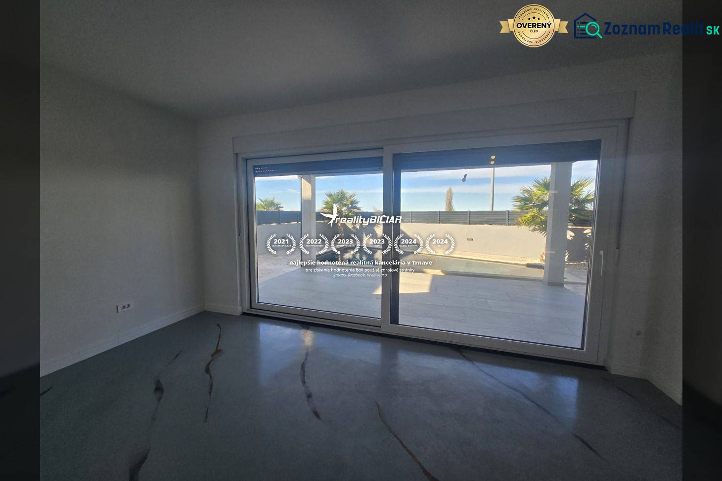 Egy nagy üvegezésű villa belső tere, kilátással a külső medencére.