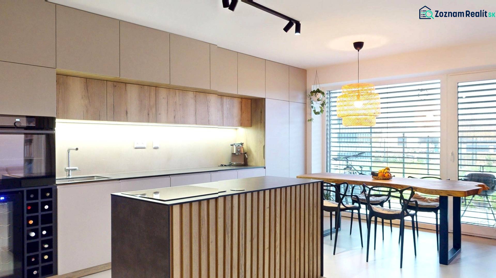 Családi ház konyhája fa dekorációjú bútorokkal és nagy ablakokkal.