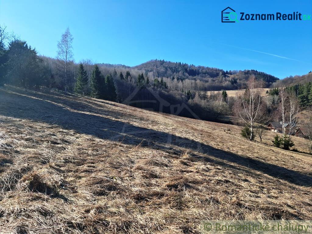 Mezőgazdasági és erdőterületek Hroncban, háttérben füves dombokkal és fákkal.