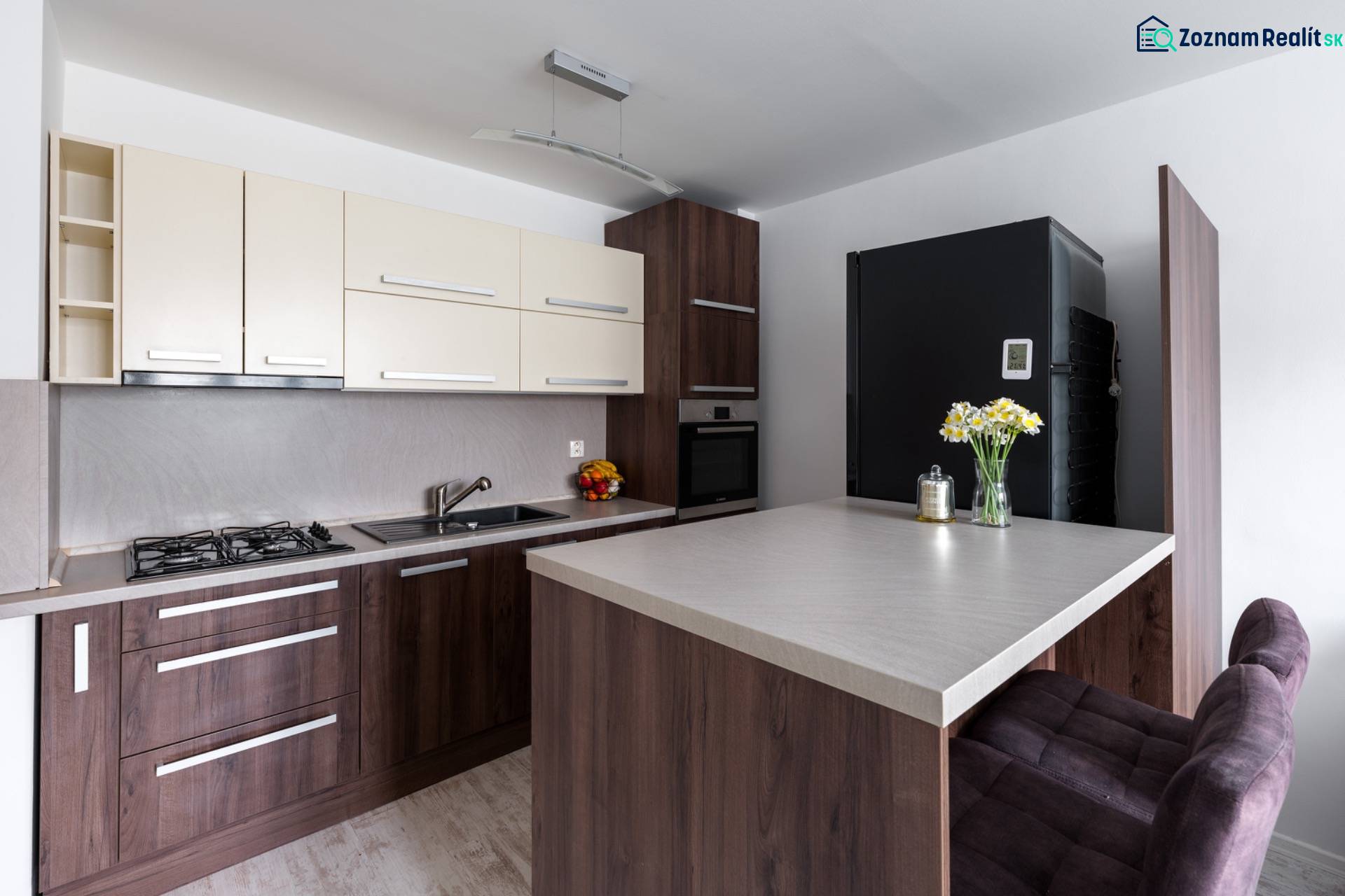 Konyha egy kétszobás lakásban fa dekor padlóval, bárpulttal és modern felszereléssel.