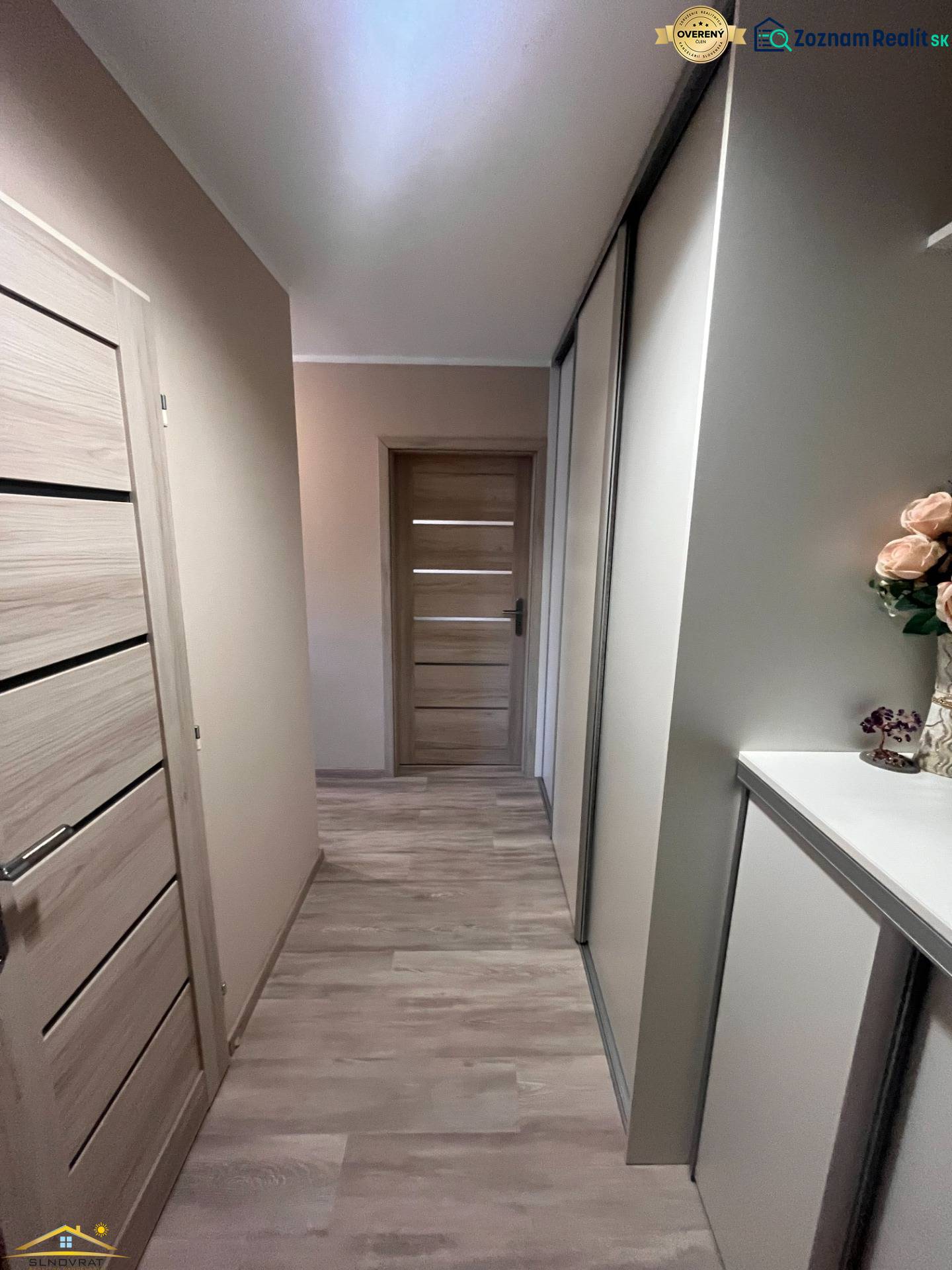 Folyosó egy 3 szobás lakásban, fa dekorációjú padlóval.