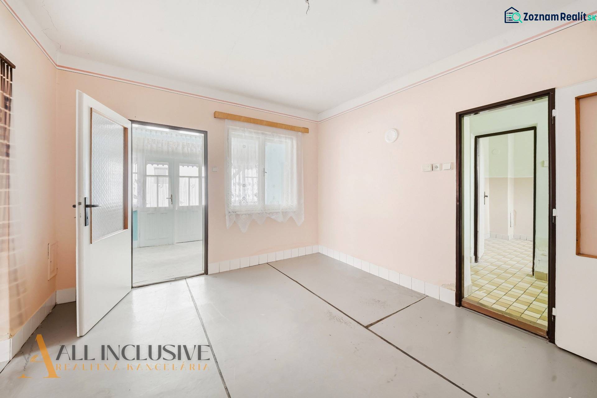 Családi ház belső tere fehér falakkal és üvegezett ajtókkal fa dekoráció nélkül.