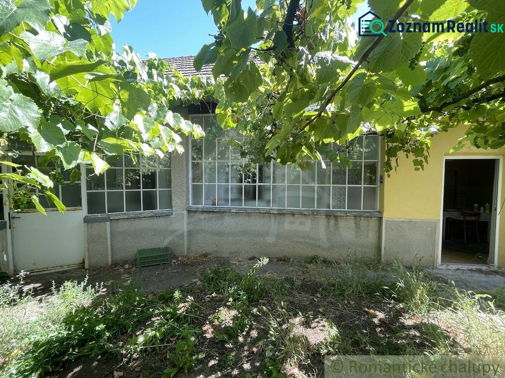 Családi ház Tardoskedden verandával, zölddel körülvéve, kert szőlővel.