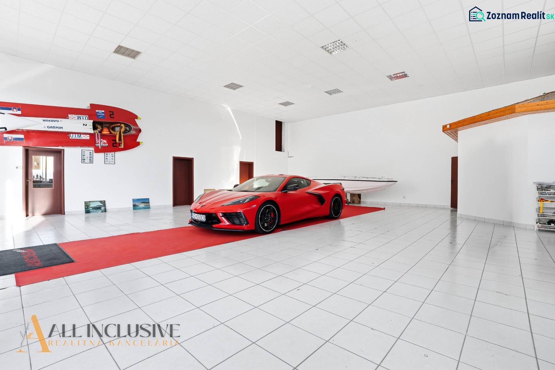 Az üzlethelyiség egy autót és egy hajót mutat be fehér padlóval és sportfelszereléssel.