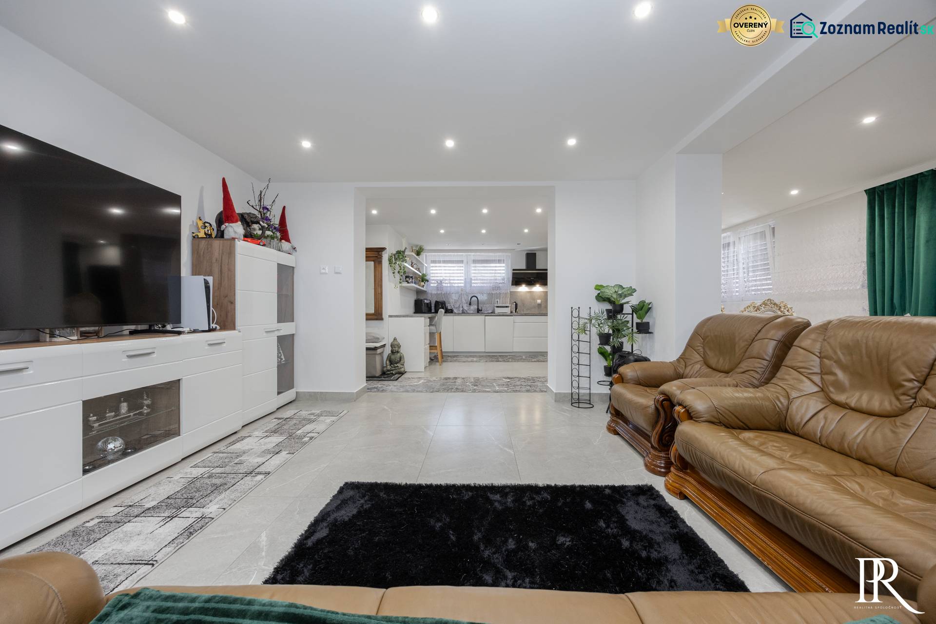 Nappali bőr bútorokkal, csempe és konyhasarok egy családi házban.