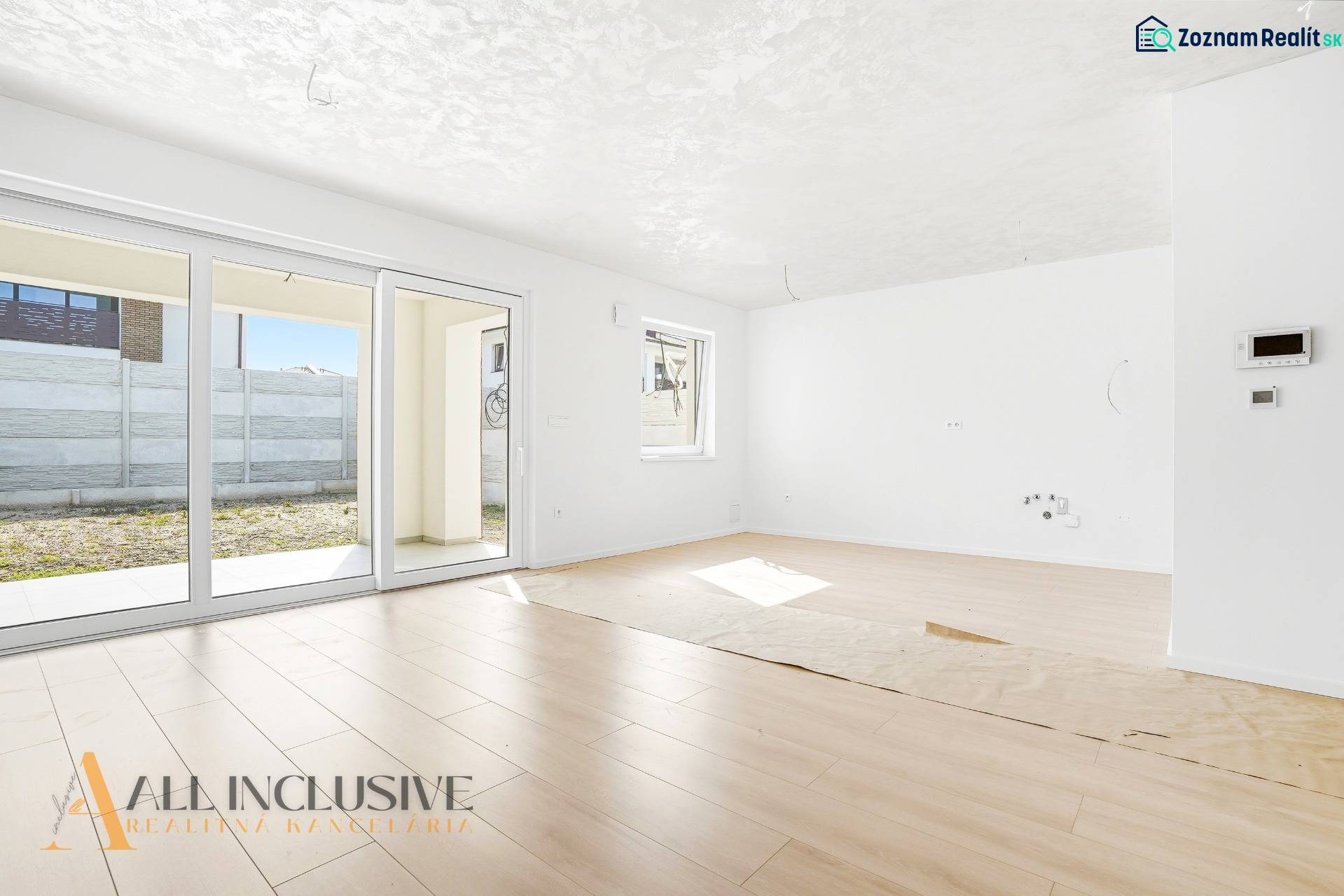 Világos nappali egy háromszobás lakásban, fa dekorációjú padlóval.