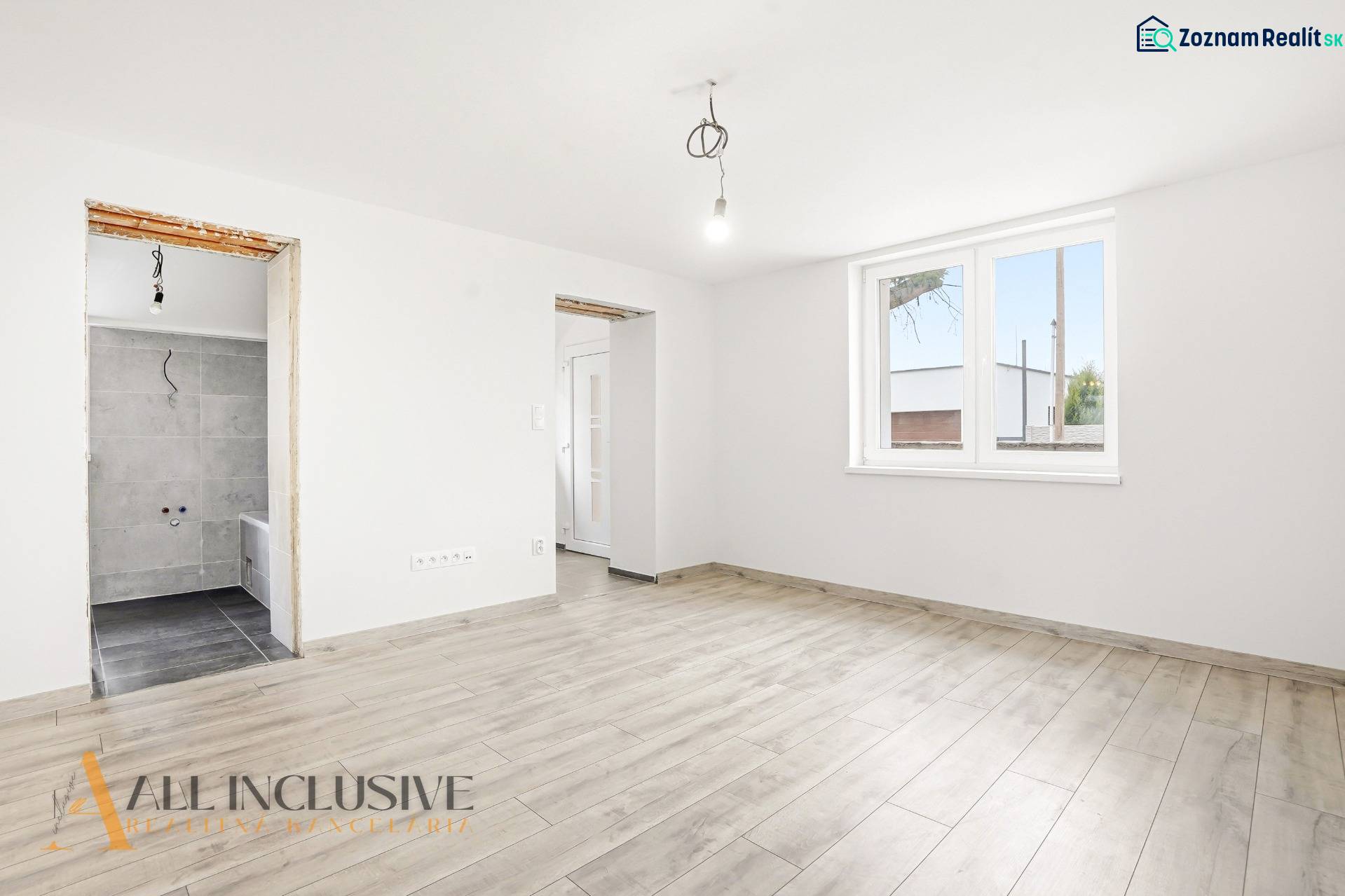 Családi ház belső tere fa dekoros padlóval és nagy ablakkal.