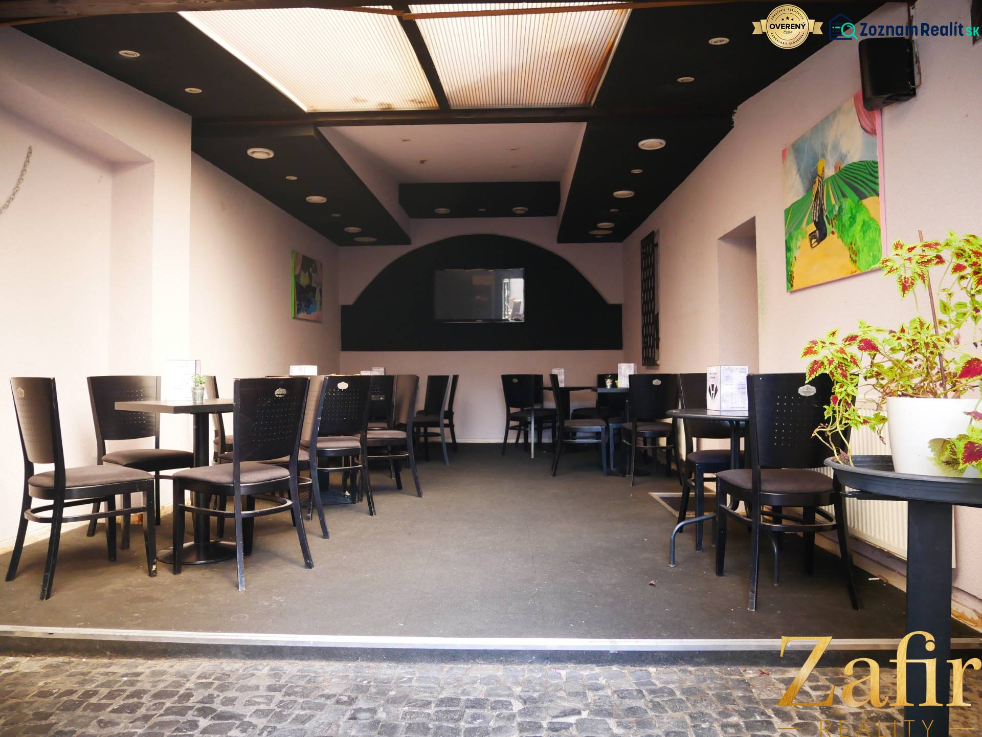 Belső vendéglátó terek ülőhelyekkel, dekorációkkal és szobanövénnyel.