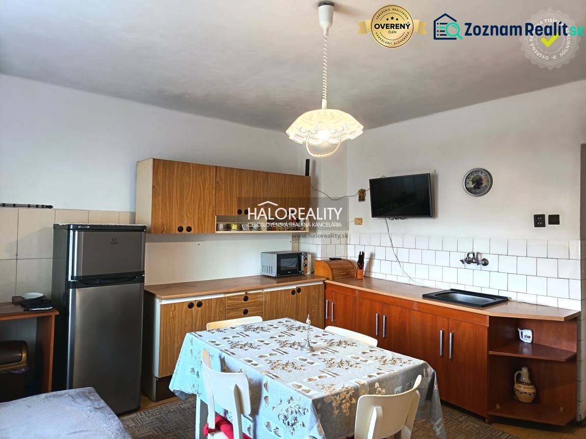 Konyha családi házban fa konyhabútorral és étkezőasztallal.