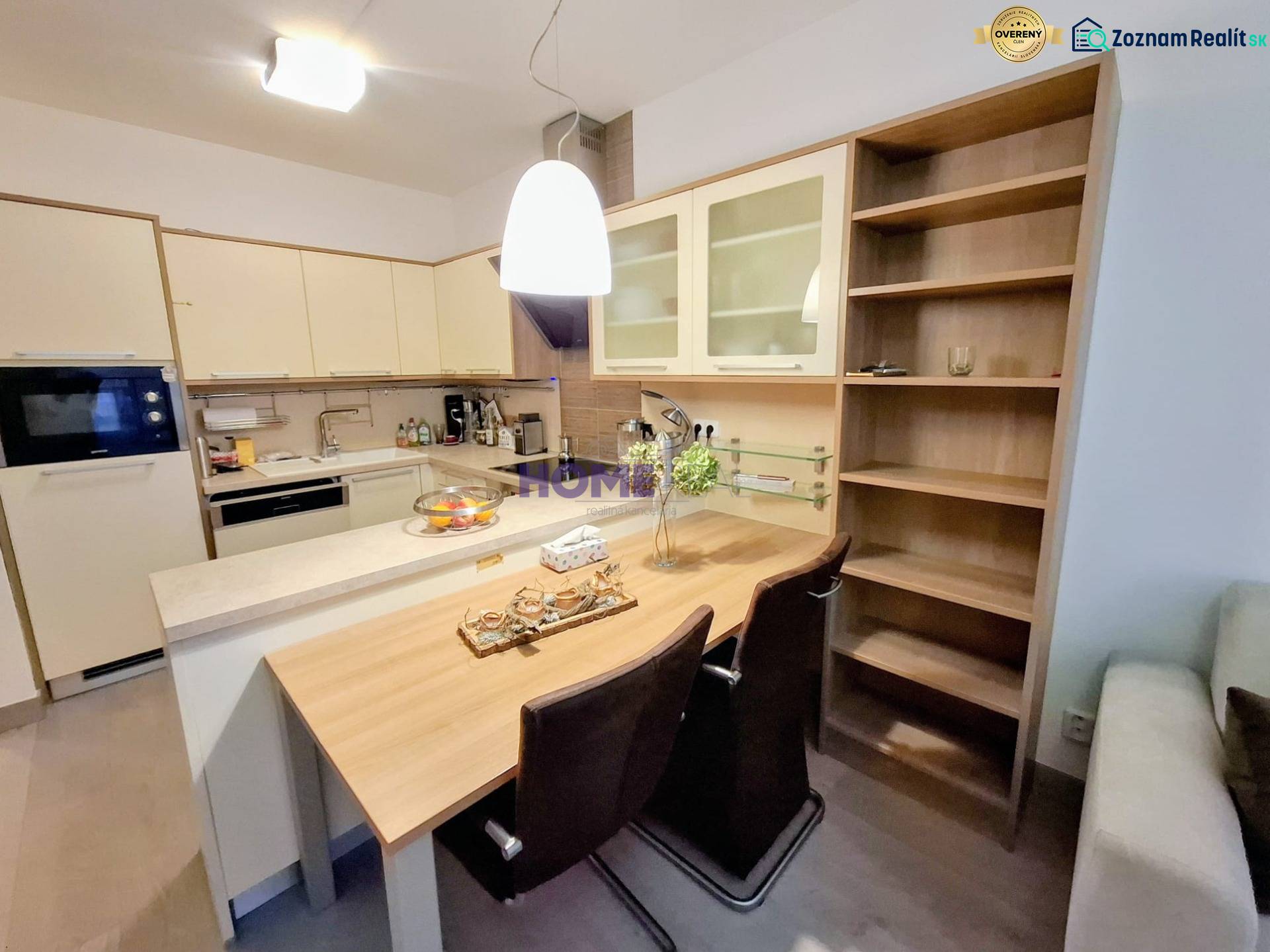 Konyhai tér egy kétszobás lakásban bárpulttal és beépített szekrényekkel.