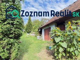 Családi ház Krivosúd-Bodovkán piros ajtókkal és napraforgókkal a kertben.