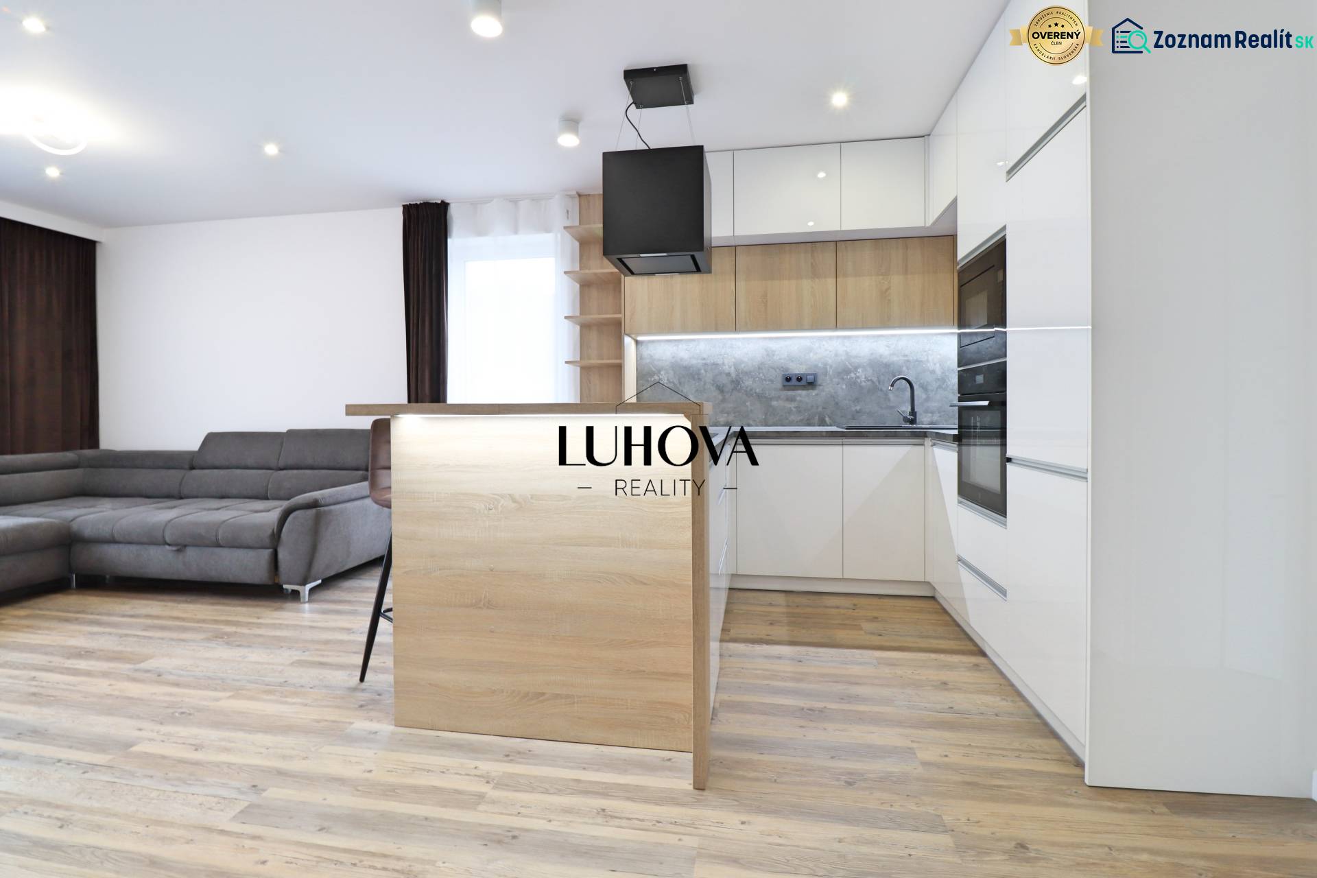 Nappali konyhával és fa dekoros padlóval egy háromszobás lakásban.