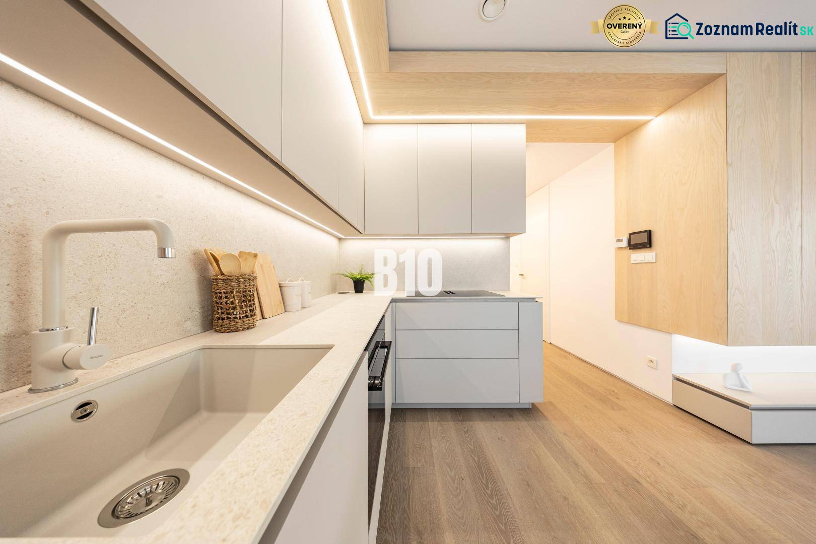 Konyha egy háromszobás lakásban, fa dekor padlóval és minimalista dizájnnal.