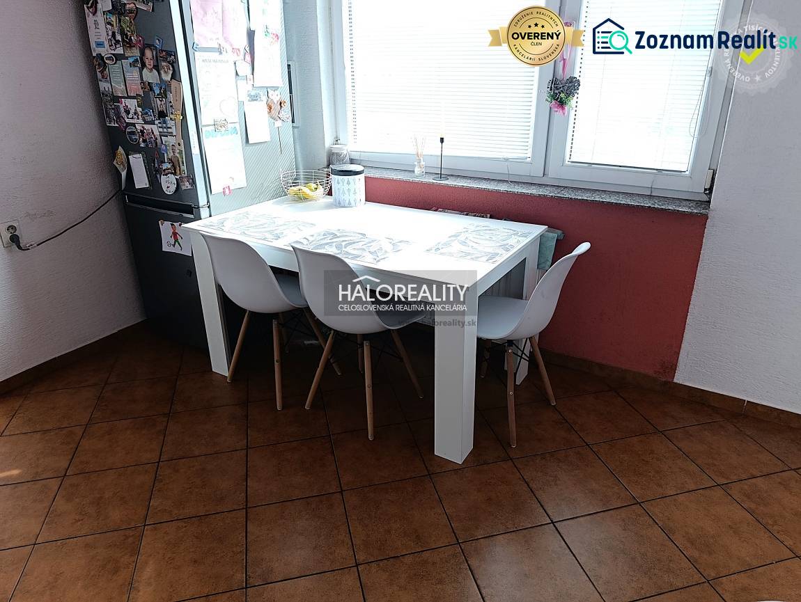 Két szobás lakás konyhája étkezőasztallal, fehér székekkel és ablakkal.