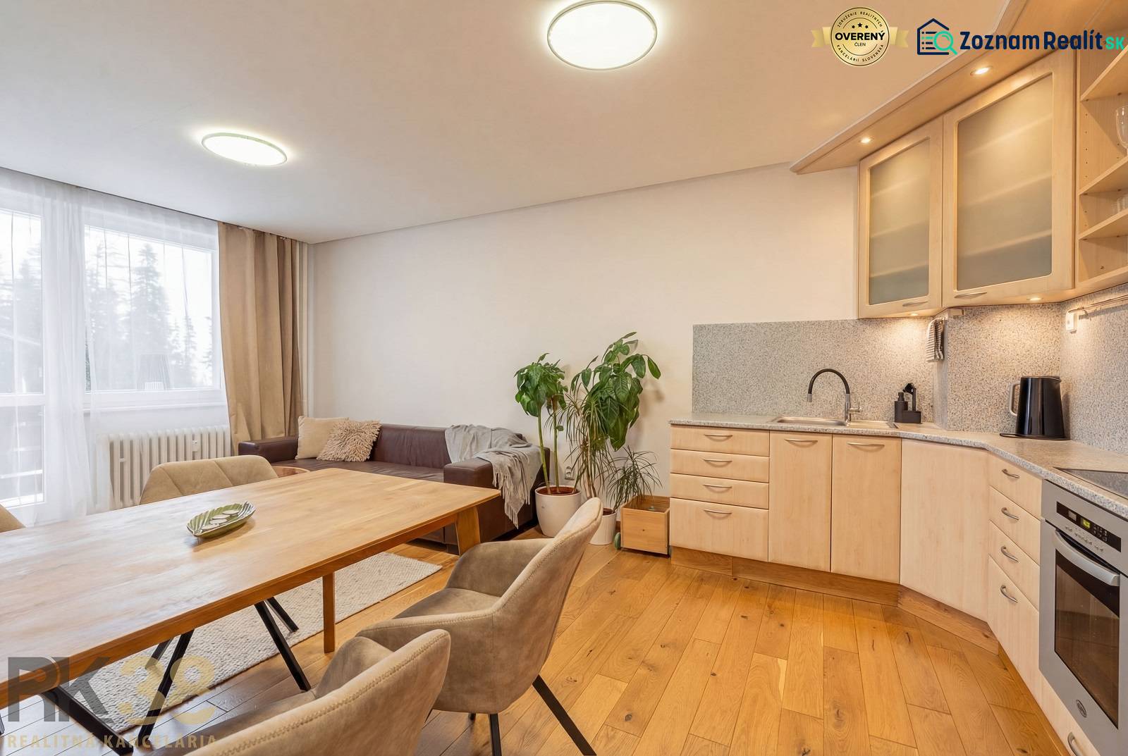 Nyaraló apartman belső tere kanapéval, konyhával és fa dekorációjú padlóval.