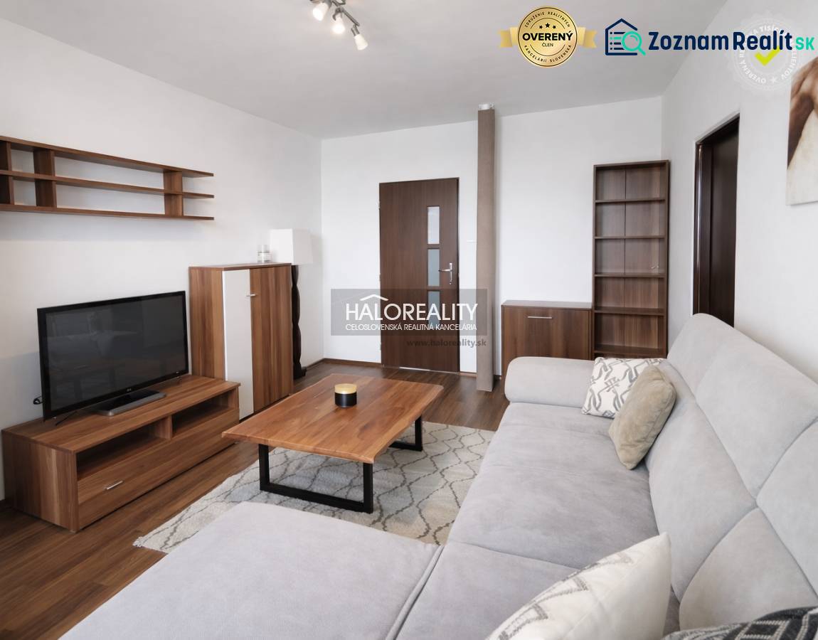 Nappali szoba fa hatású padlóval, kanapéval és televízióval egy négy szobás lakásban.