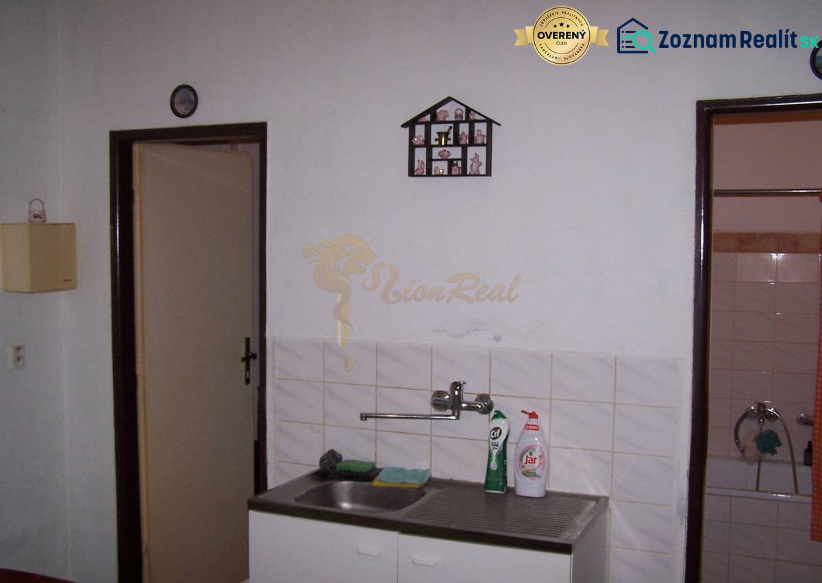 Konyha függő edényszárítóval a mosogató mellett egy kétszobás lakásban.