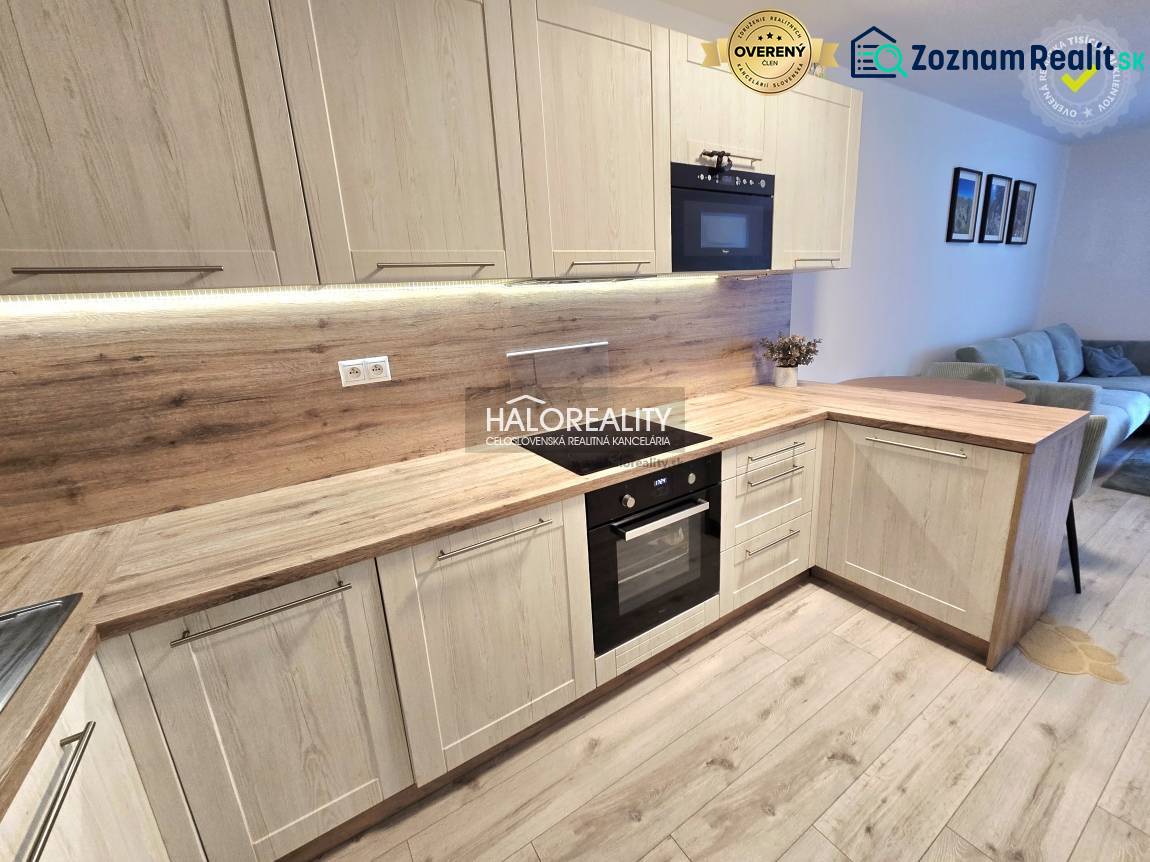 Konyha fa dekor padlóval egy kétszobás lakásban, világos fa szekrényekkel és beépített készülékekkel.