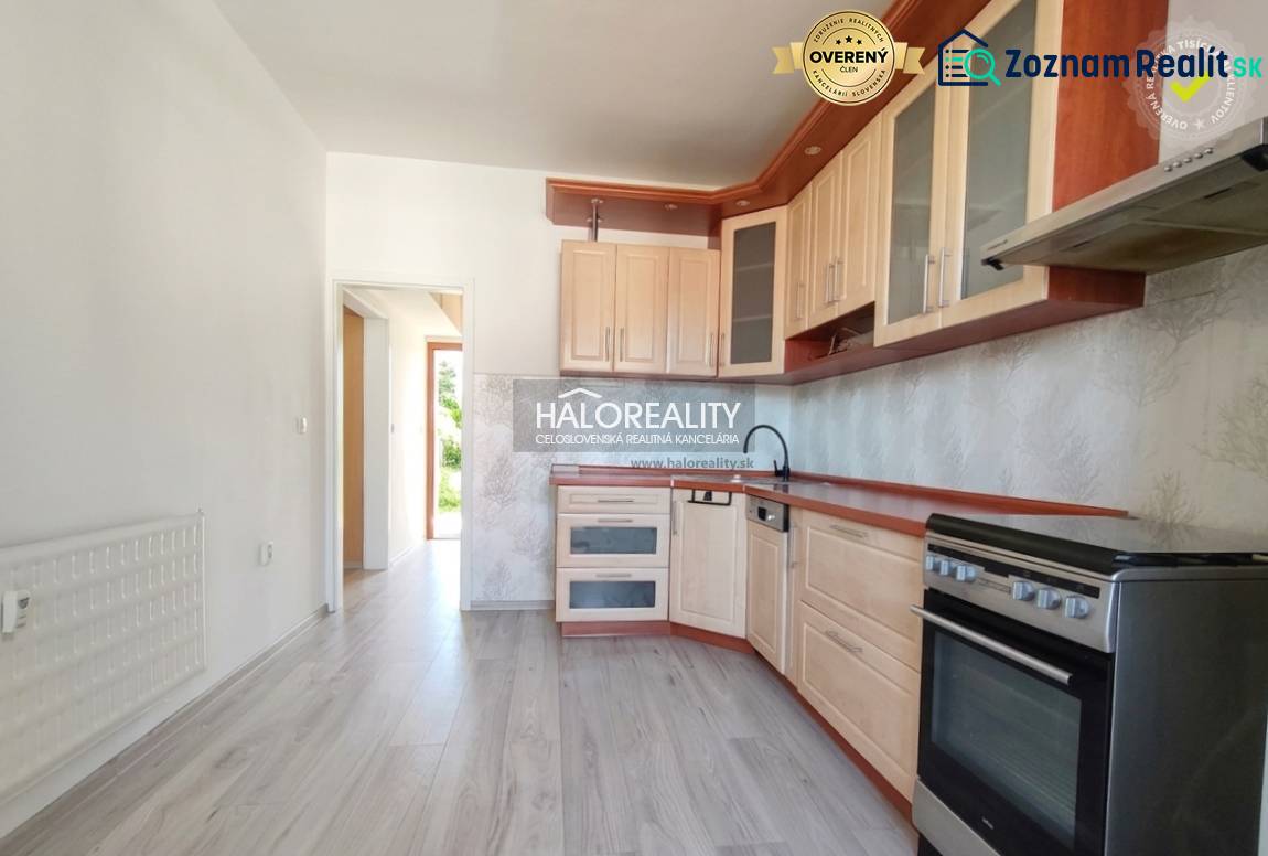 Konyha egy háromszobás lakásban, fa dekor padlóval és világos bútorokkal.