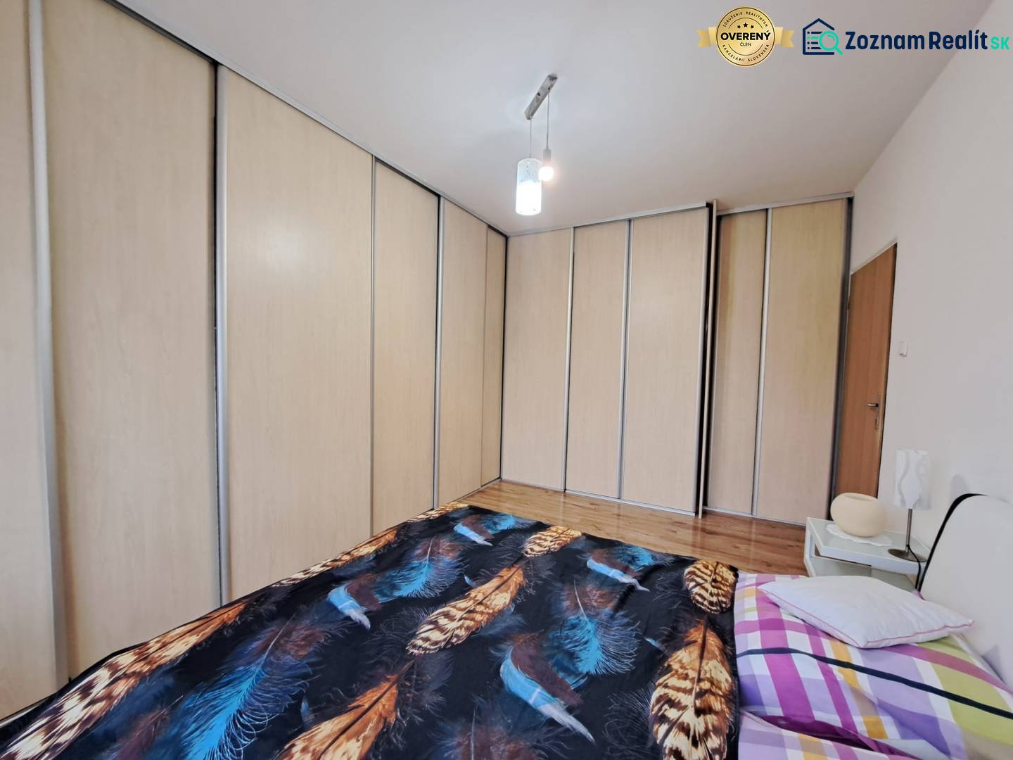 Hálószoba nagy beépített szekrénnyel és ággyal egy kétszobás lakásban.