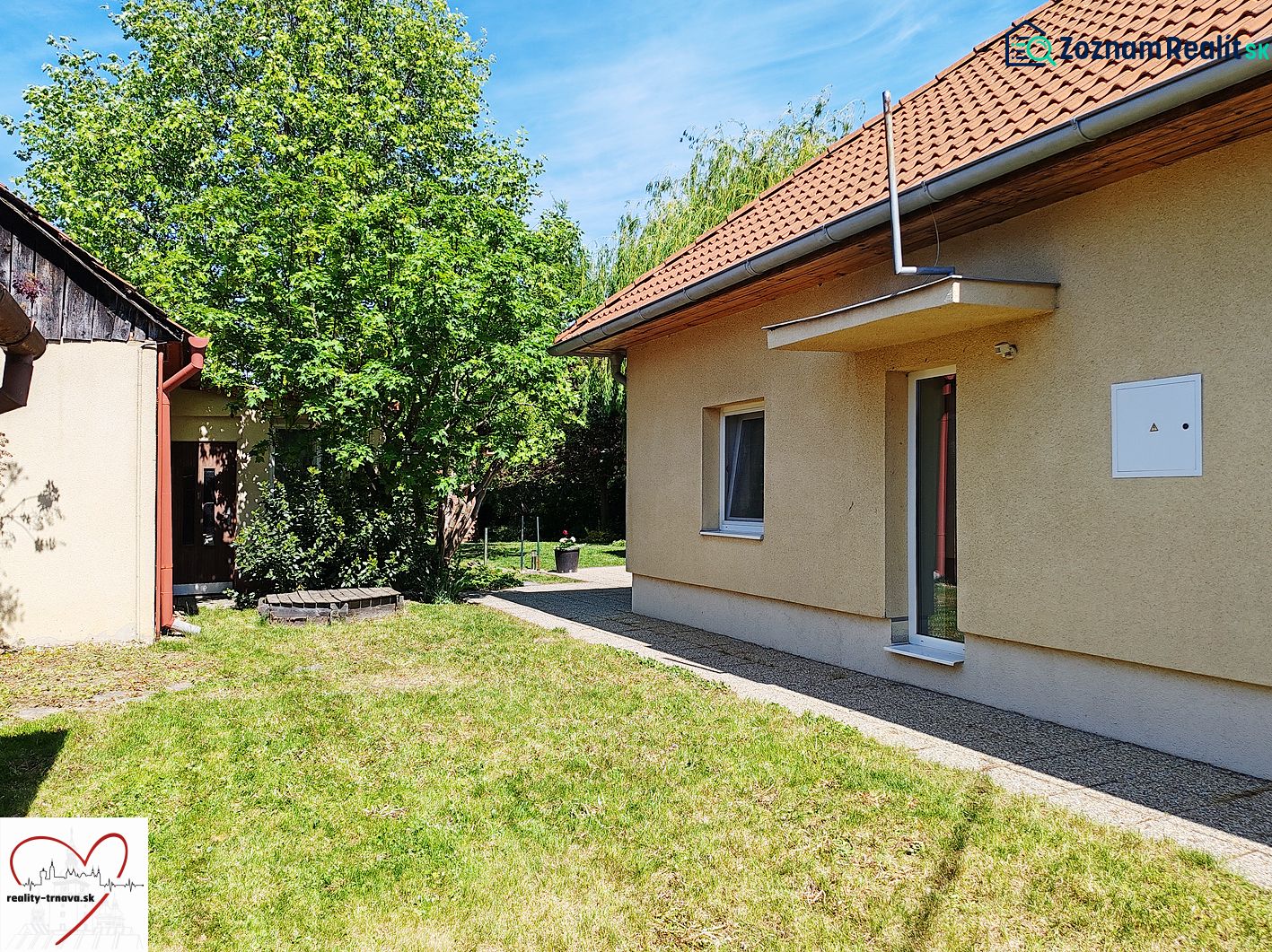 Családi ház a Sládkovičovo Devátova utcájában gyepesített udvarral és fákkal.