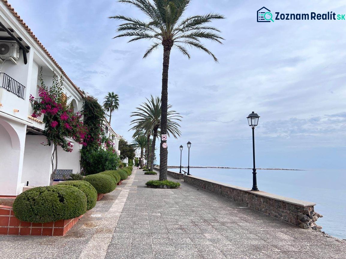 Tengerparti sétány La Manga del Mar Menorban, Spanyolország, pálmafákkal és lámpákkal szegélyezve.
