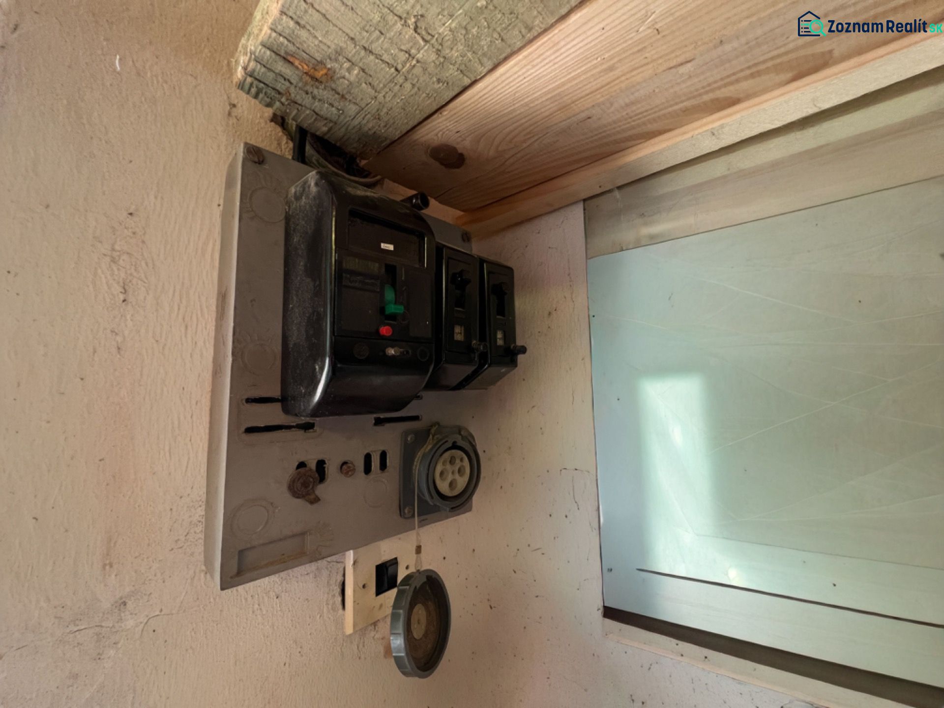 Régi elektromos elosztószekrény a garázsban, régi biztosítékokkal és aljzatokkal.