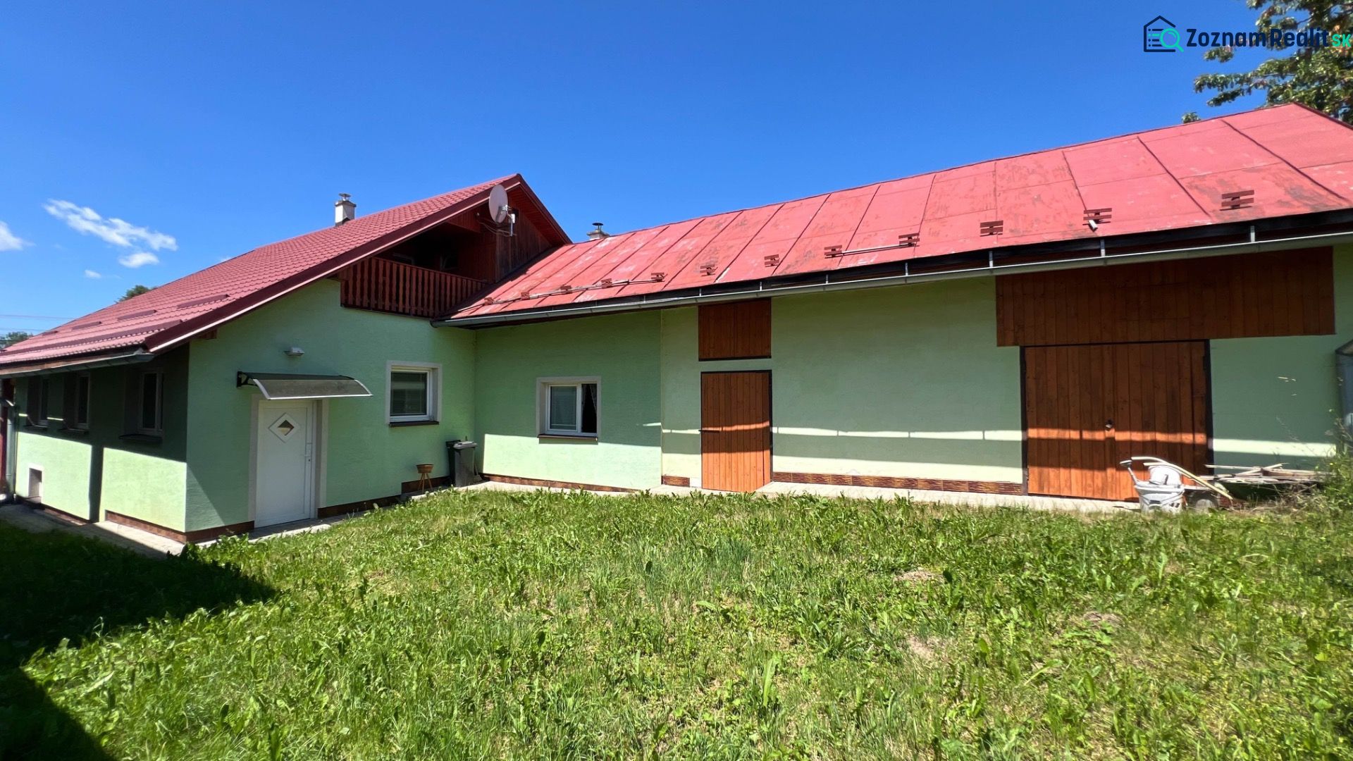 Családi ház Polomkán színes homlokzatokkal és piros tetővel a kék ég hátterében.