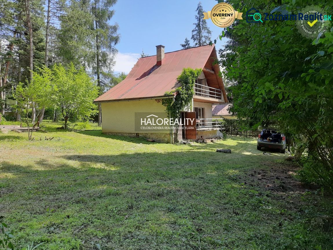 Házikó Ružinánál, fákkal és zölddel körülvéve, autóval a felhajtón.