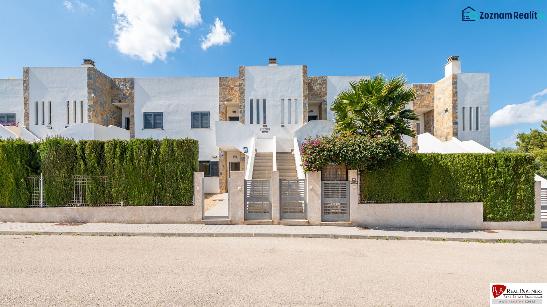 Nyaraló apartman Cala Muradában, Mallorcán, modern homlokzattal és zöld sövénnyel.