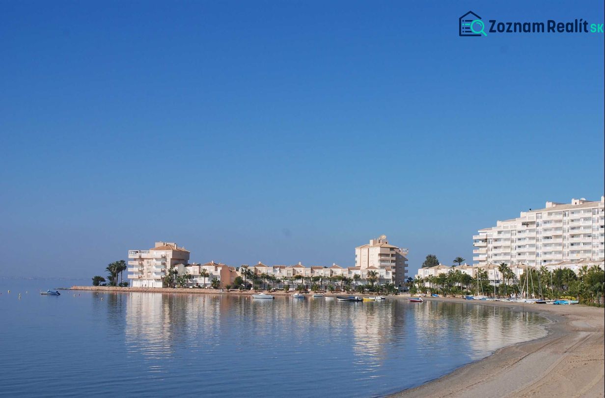 La Manga del Mar Menor tengerpartja rekreációs apartmanokkal a nyugodt tenger és a kék ég alatt.