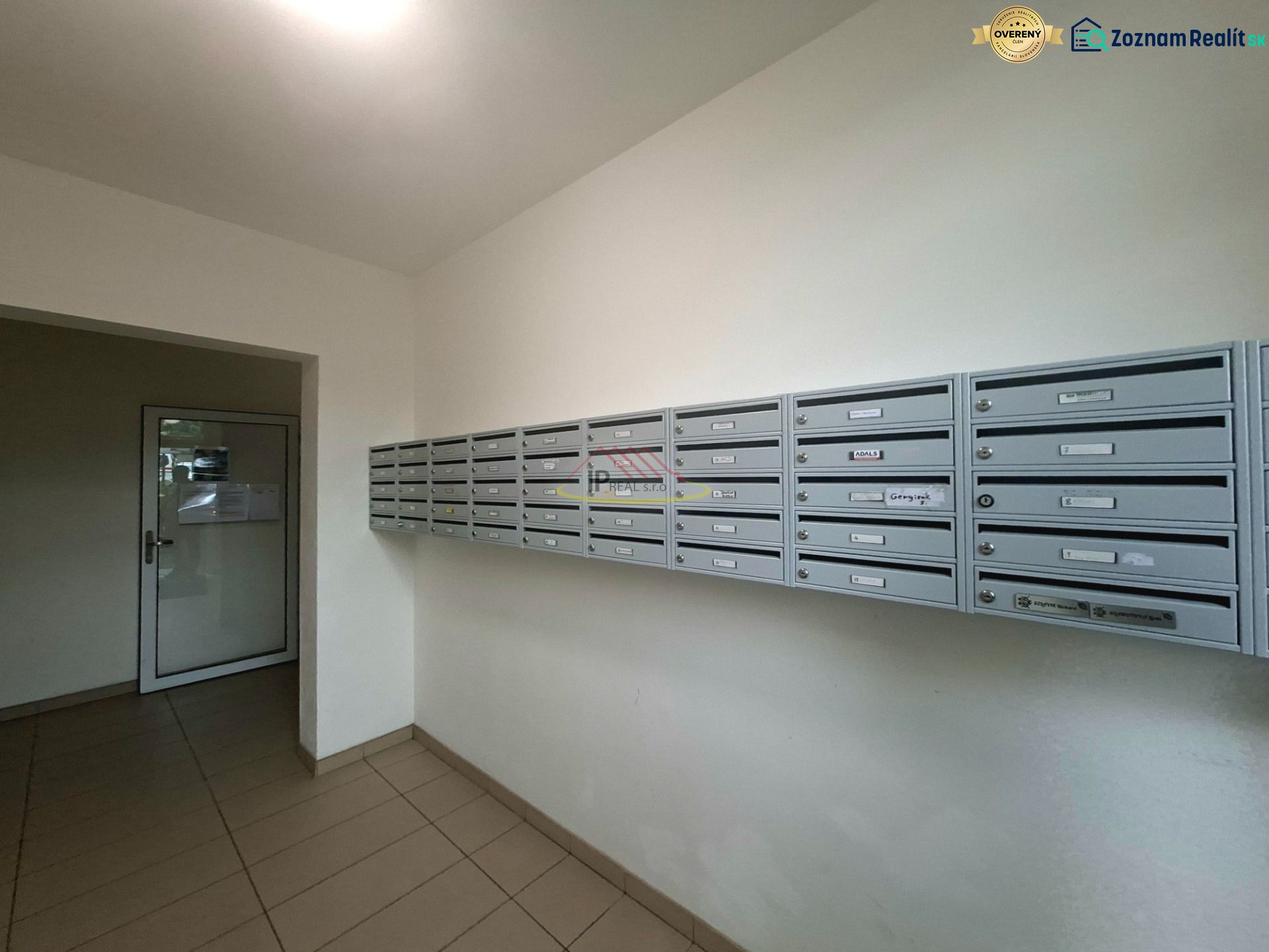 A garzonlakás előszobájában lévő postaládák, csempézett padló, egyszerű dizájn.